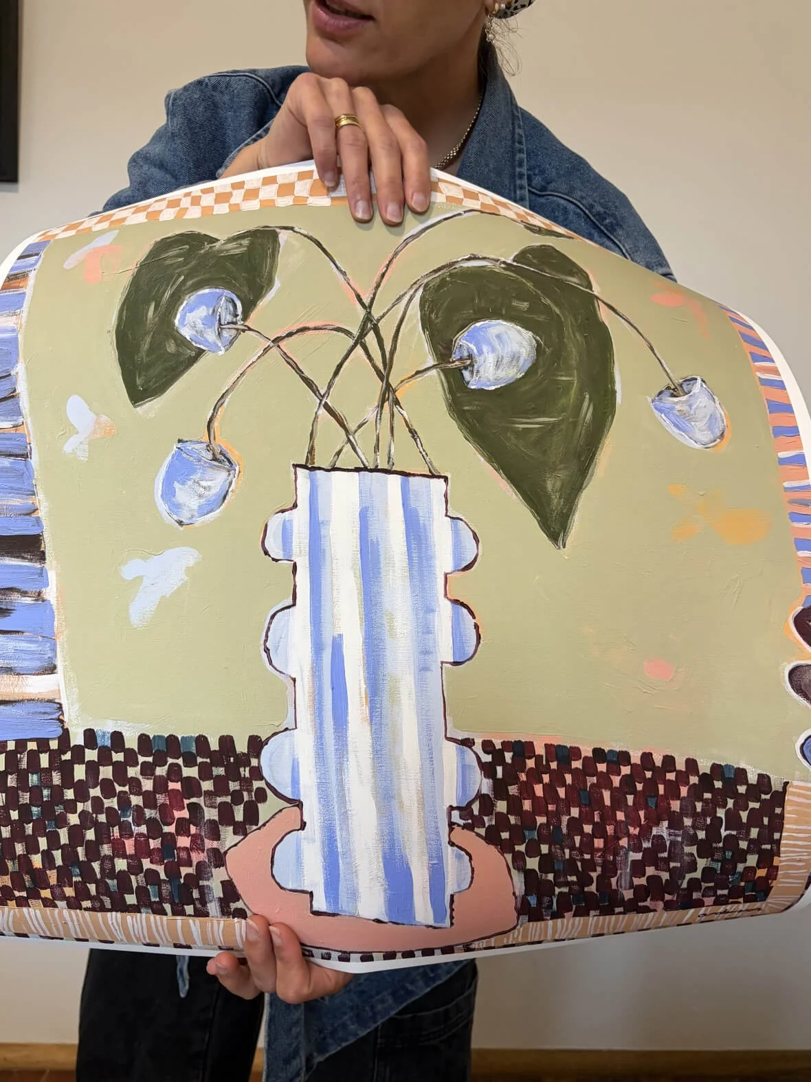 Artist Anita Robinson holding a limited edition fine art print of Not So Still to demonstrate the large square scale and thick textured paper quality.