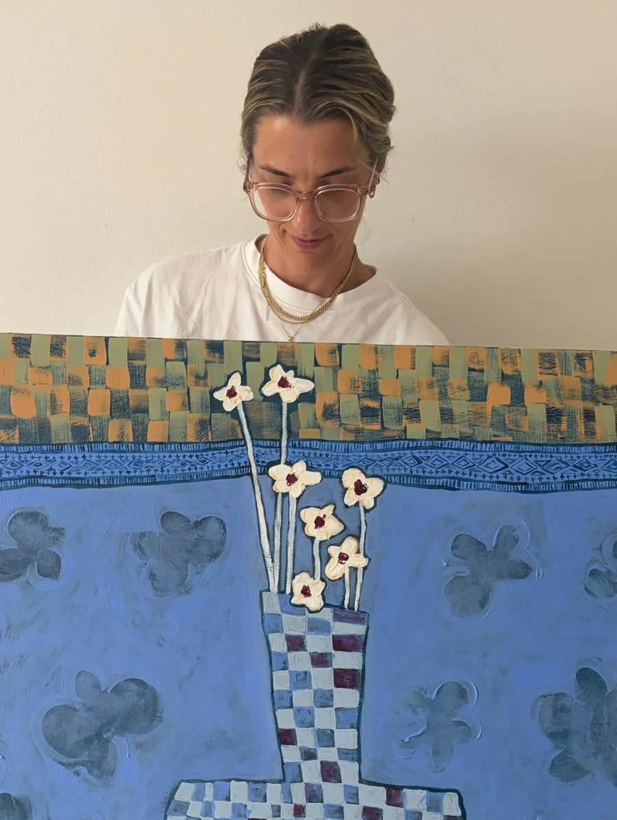 Sydney artist Anita Robinson standing next to her original abstract still life 'Stillness in Blue' in a bright, modern studio setting.