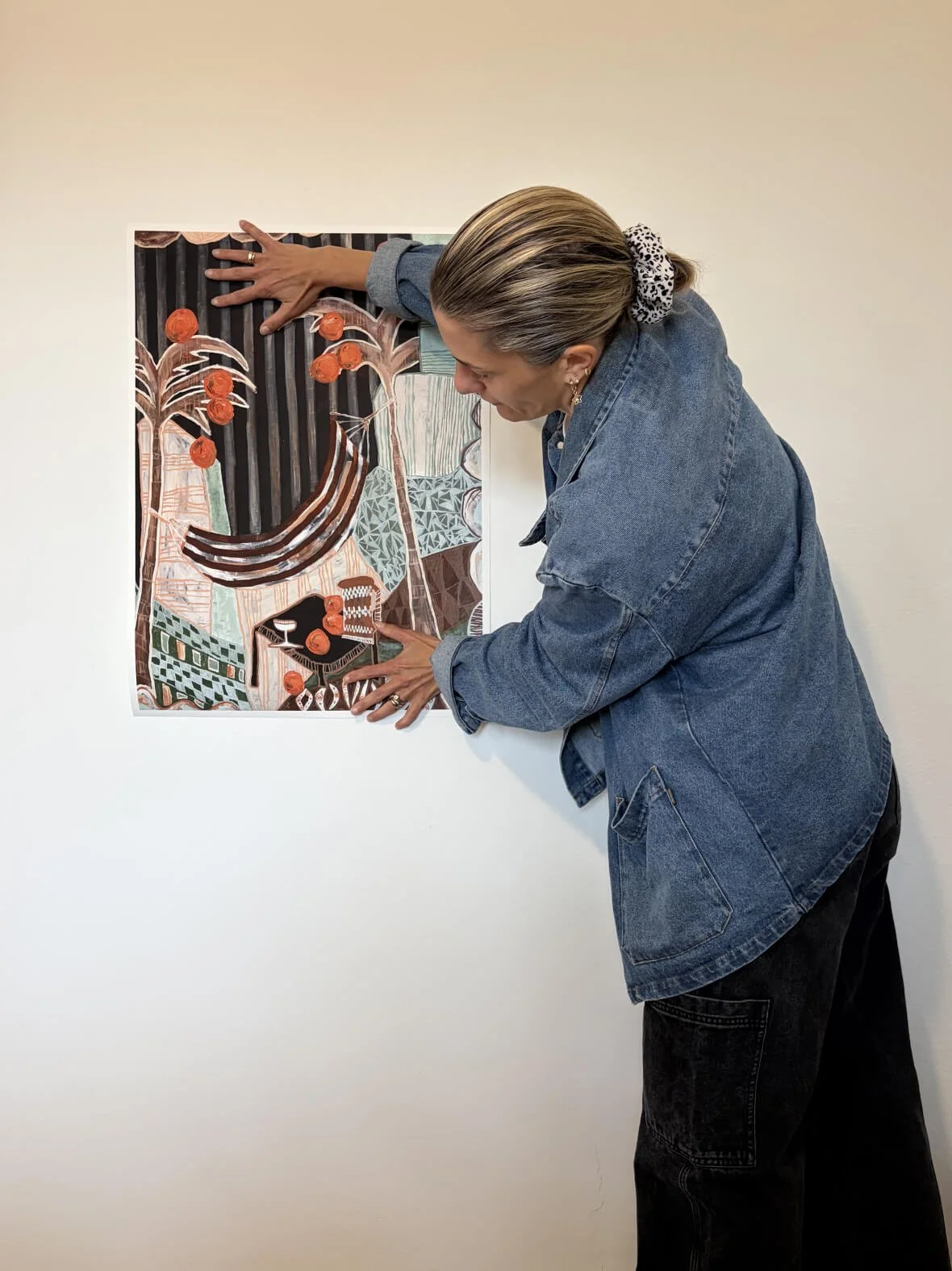 Artist Anita Robinson holding a limited edition fine art print of Falling Orange to demonstrate the large square scale and thick textured paper quality.