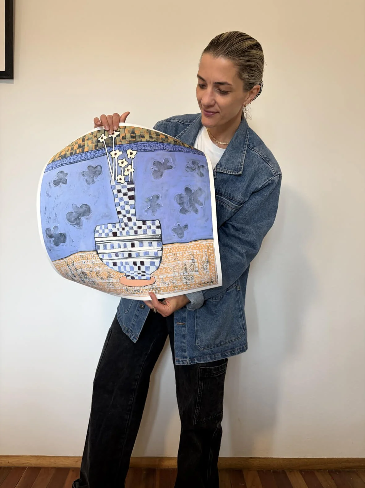 Australian abstract artist Anita Robinson holding a limited edition fine art print of Stillness in Blue to show the square scale and high-end paper quality.