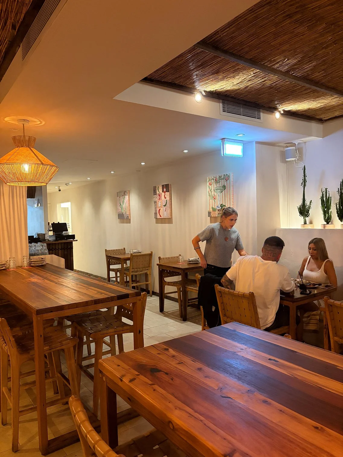 A wide lifestyle shot of the Mexican Series abstract paintings hanging in the dining area of Tijuana's Manly restaurant.