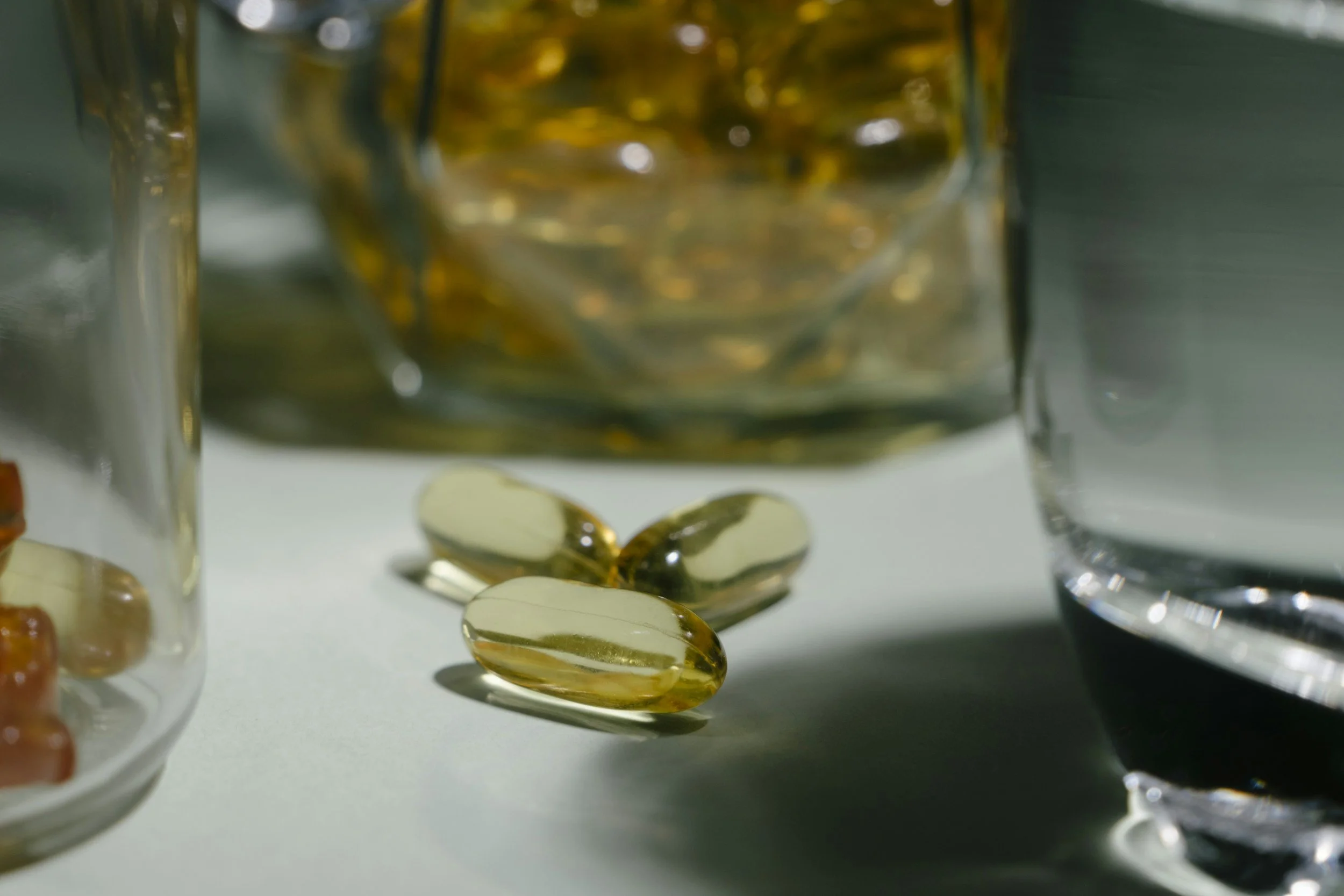 A crisp, close-up shot of three natural supplement pastilles in sharp focus on a surface, with a blurred jar of the product in the background, representing wellness and natural health content for Manuka Health.