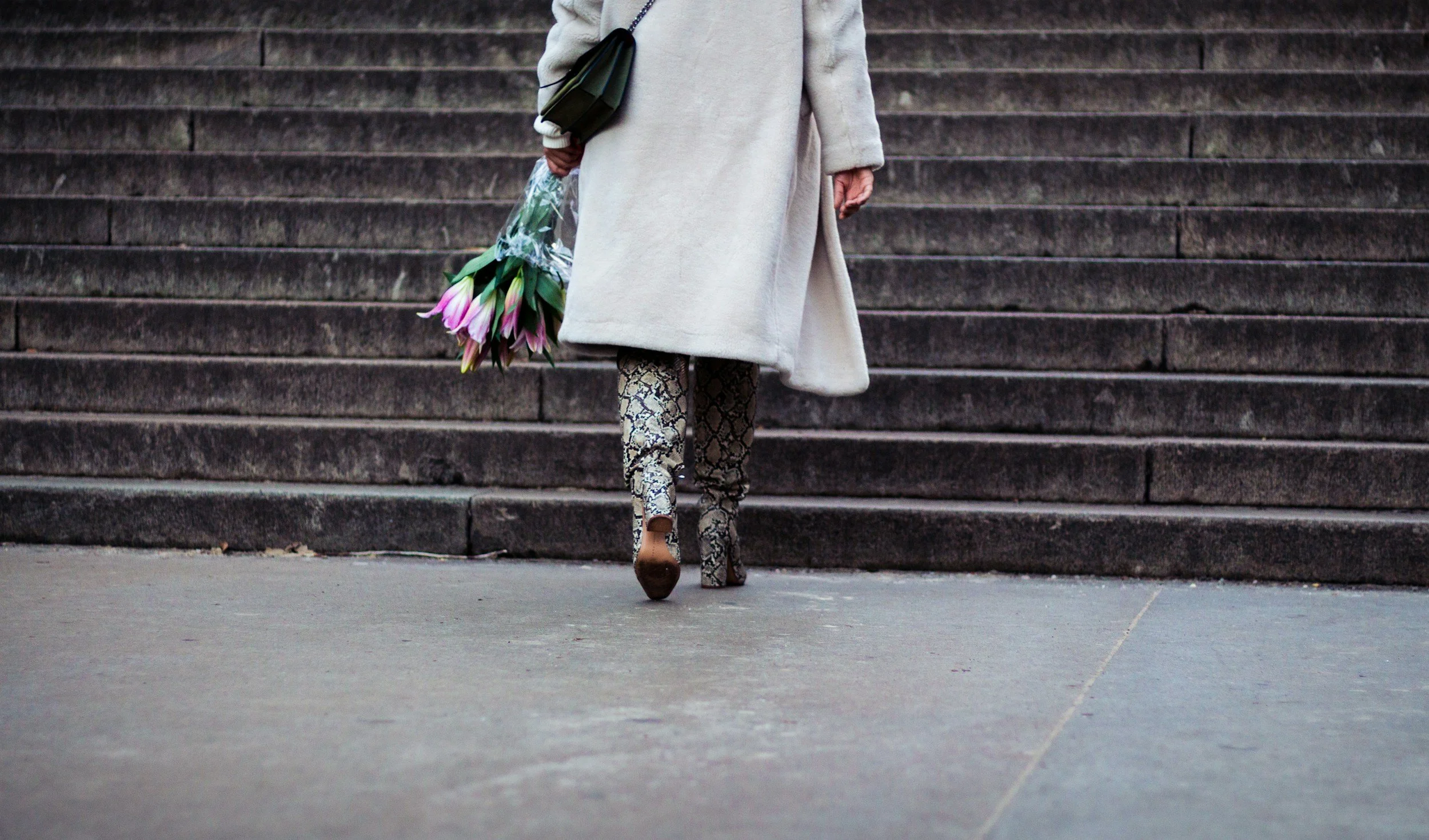 woman in heeled boots with flower bouquet after trauma therapy nyc
