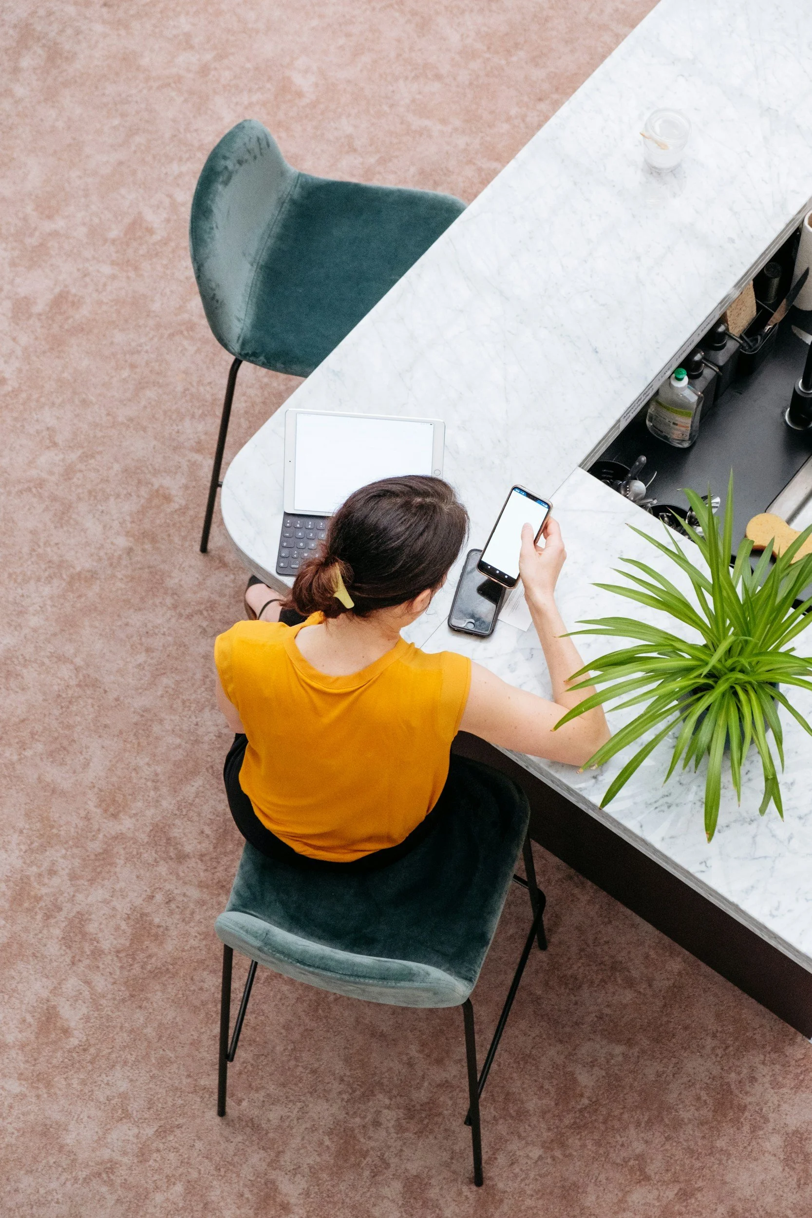 professional woman at a desk looking at her phone and wanting cbt therapy nyc