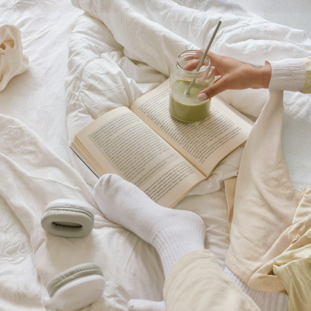 person resting in bed holding a drink, a quiet moment of ease, representing anxiety therapy for high-achieving New Yorkers with Hilary Kopple