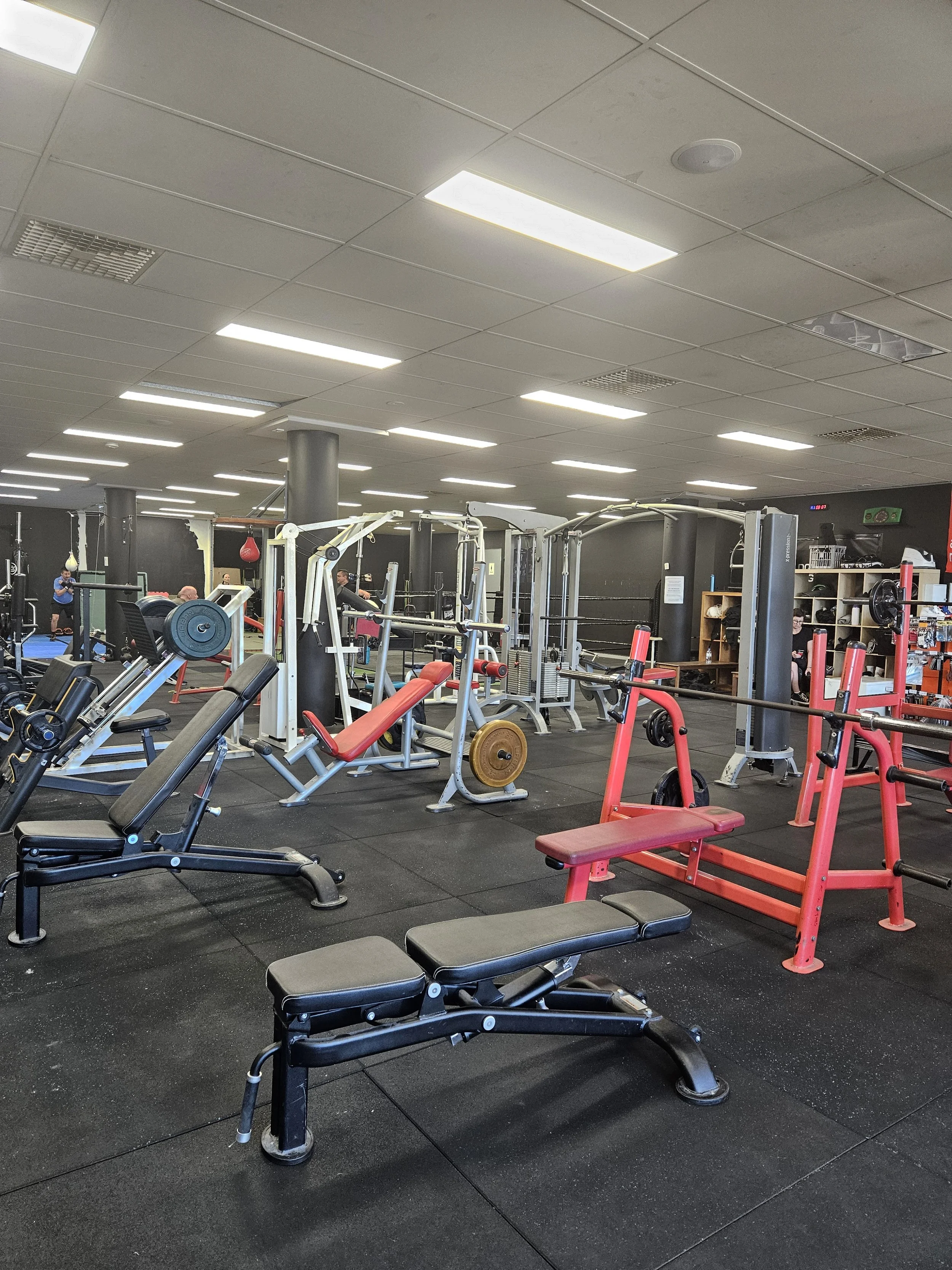 Interior of a gym with various workout equipment and weights.