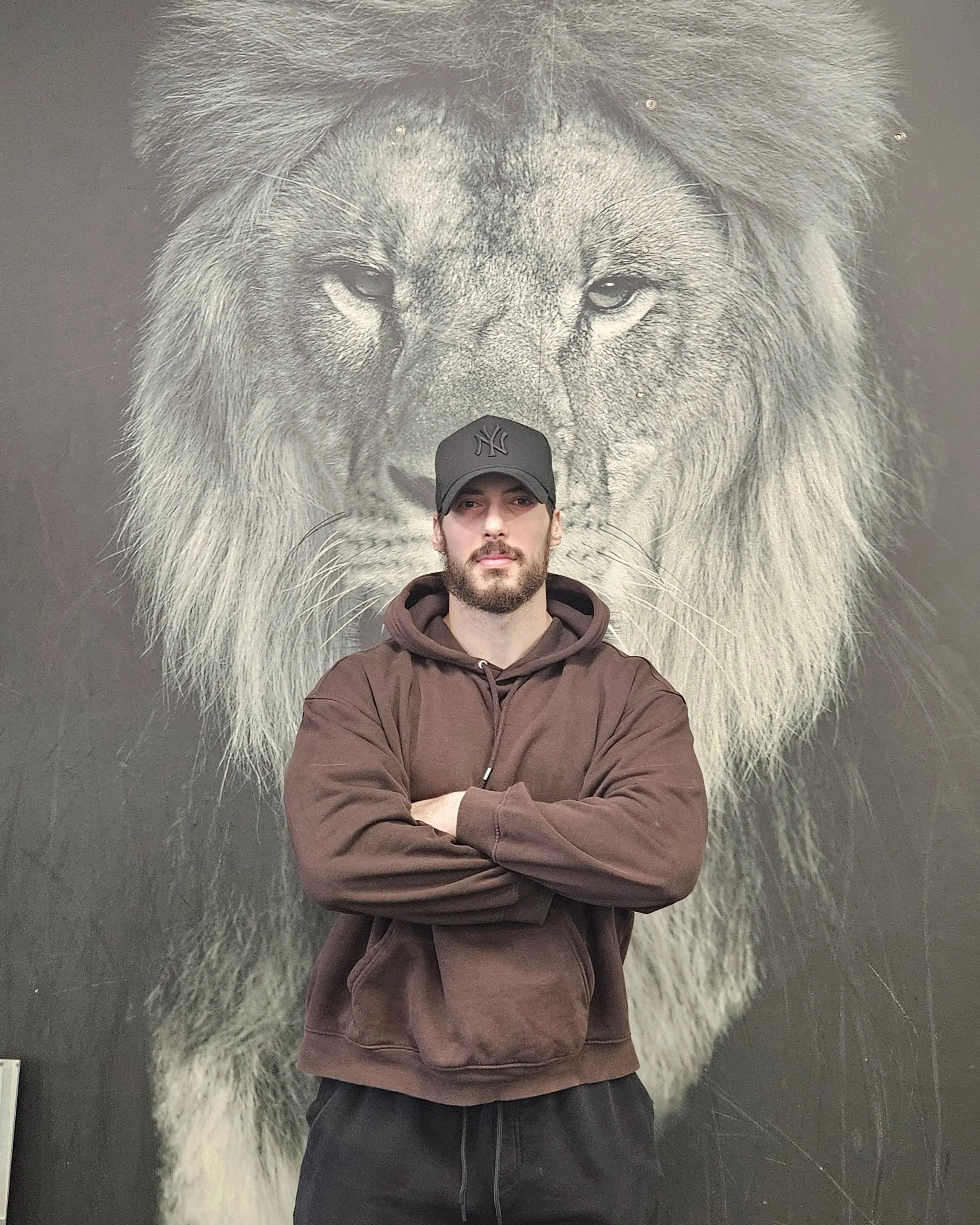A personal trainer in a gym doing a squat exercise and posing for the camera.