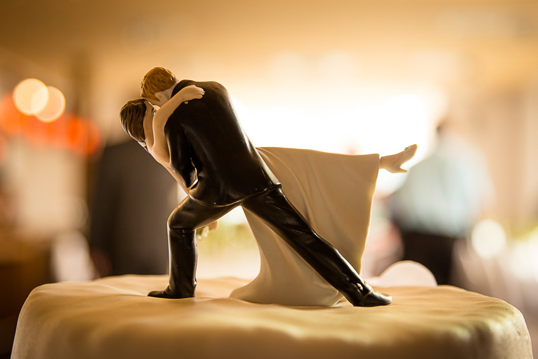 Tortenfigur eines tanzenden Paares in formeller Kleidung, auf einer Hochzeitstorte