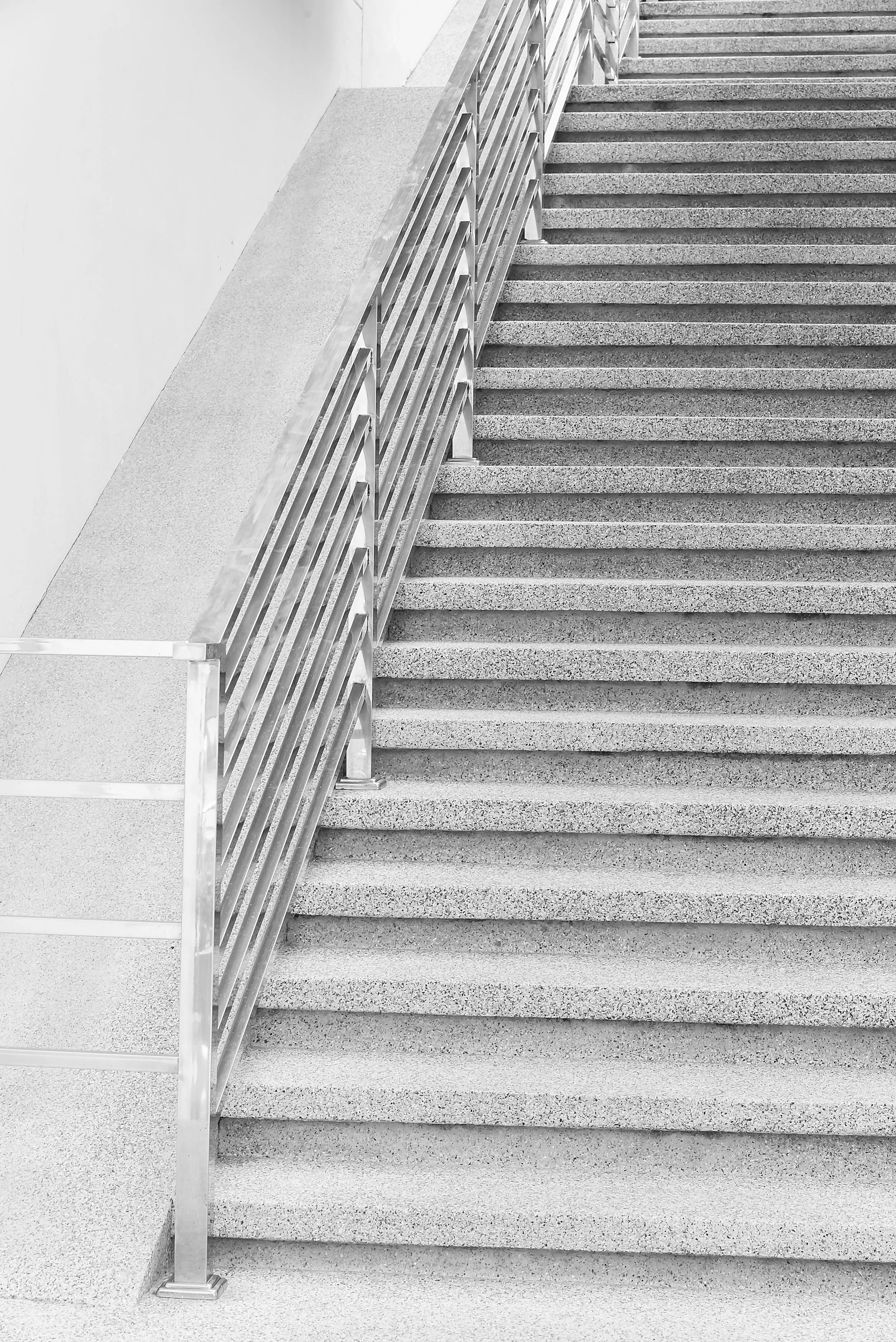 Escalier en béton avec une rampe en métal dans un bâtiment moderne.