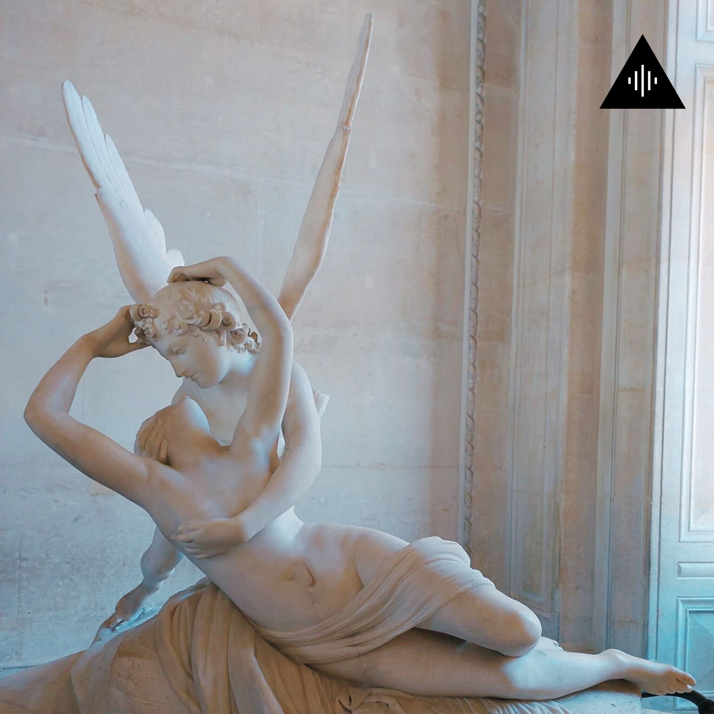Classical marble sculpture of a reclining male figure with wings, holding a woman, in a museum setting.