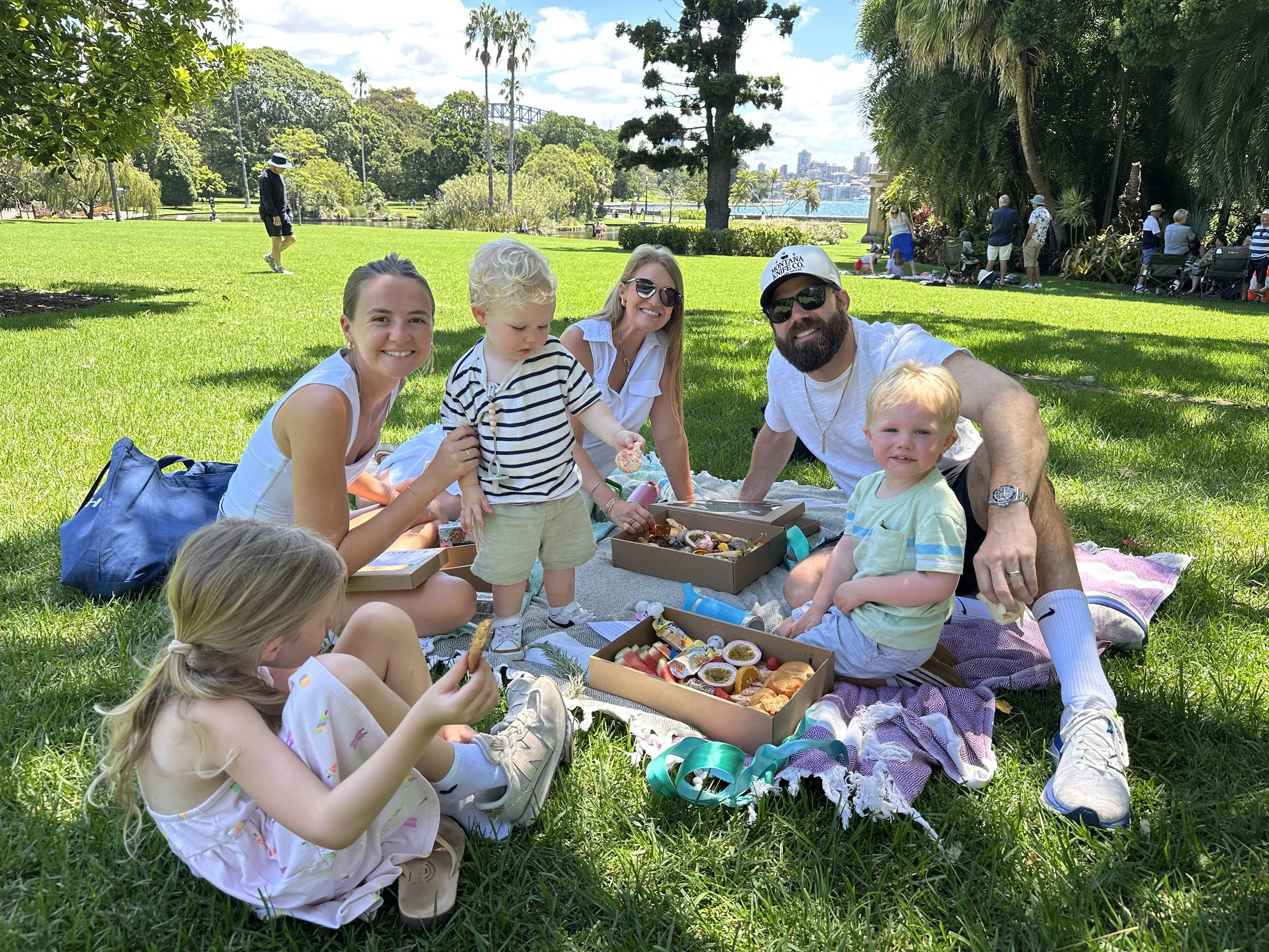 Family enjoying a premium Sydney picnic experience at the Royal Botanic Garden with harbour views