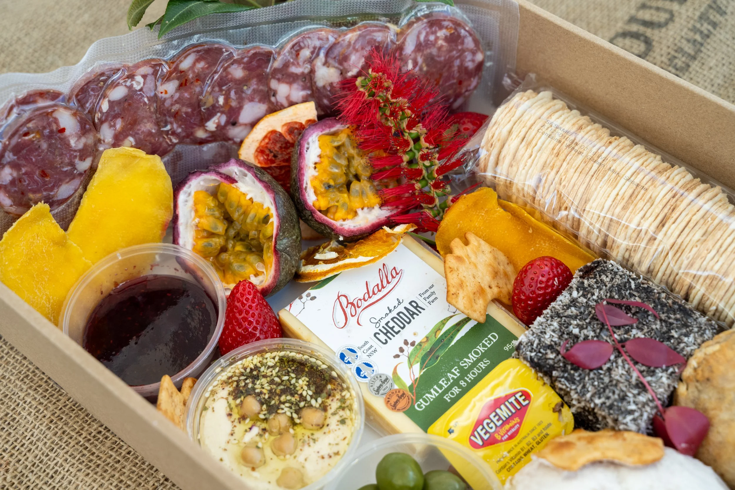 Bush Tucker Hamper Close-Up
Description: A gourmet hamper from The Australian Food Guy featuring native Australian food such as smoked cheddar, bush tucker dips, kangaroo salami, and artisan treats. Award-winning hampers perfect for picnics and gift
