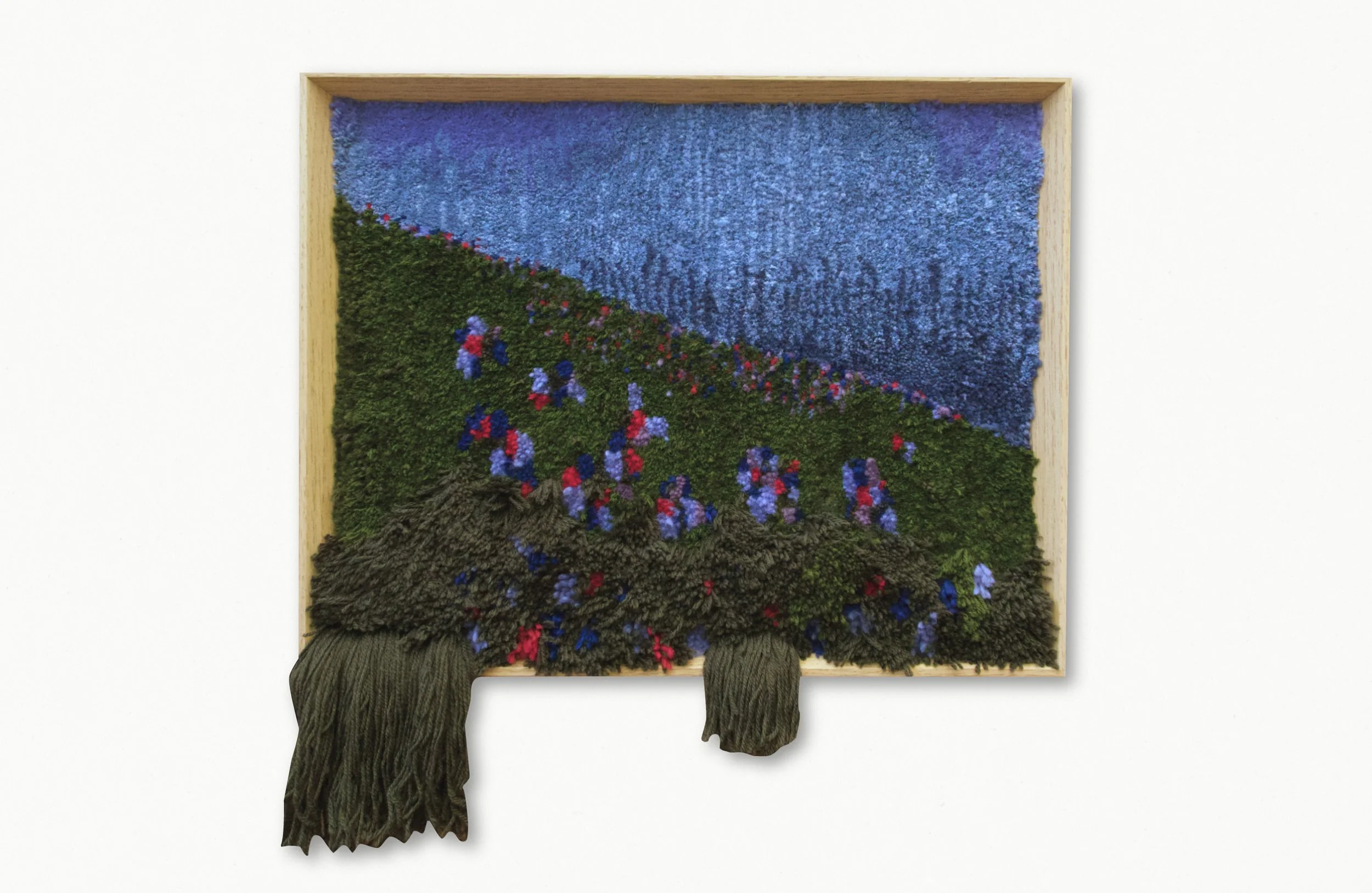 Mixed media art piece resembling a framed landscape with textured materials depicting sky, grass, and trees.