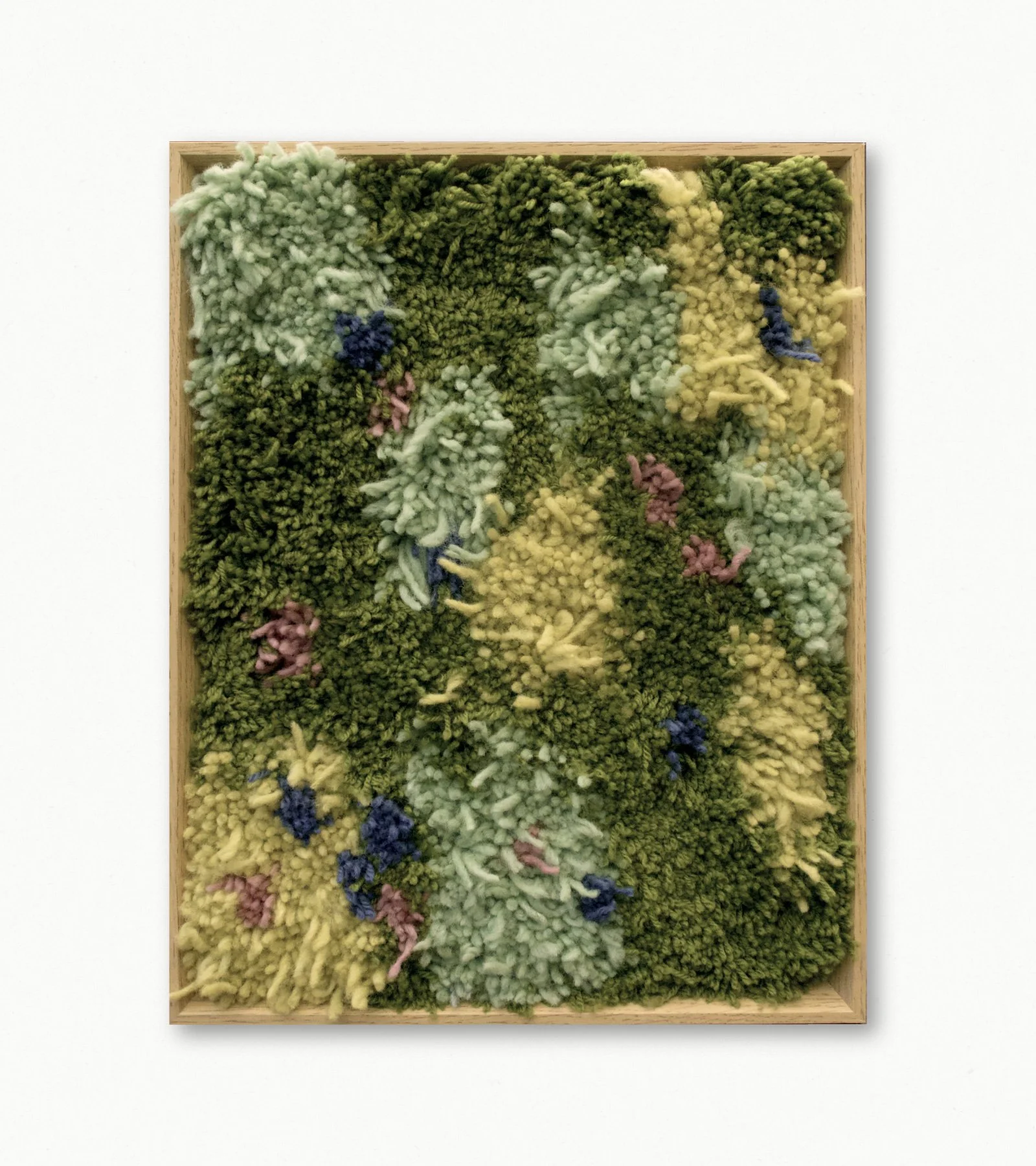 Textured mixed-media artwork with various green, yellow, and pink yarns arranged in an abstract pattern, framed by a wooden border, on a white background.