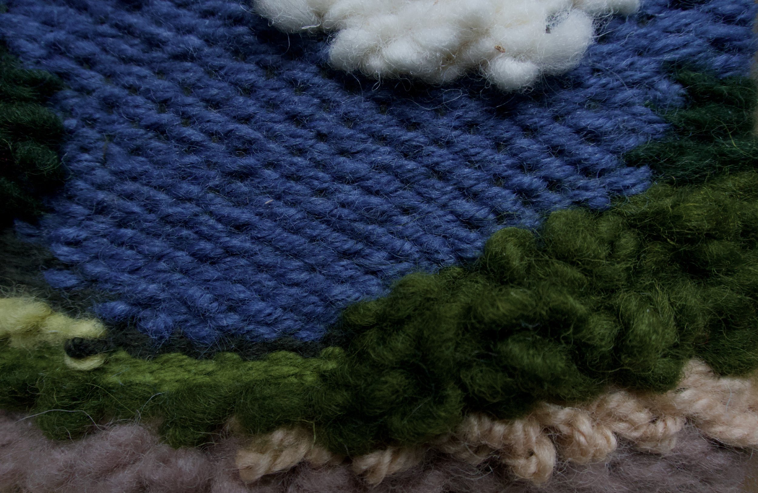 Close-up of colorful knitted fabric with white and brown wool accents.