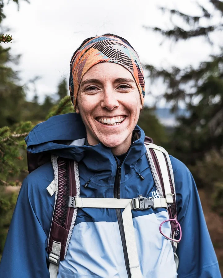 A portrait photo of a woman in outdoor clothing smiling into the camera