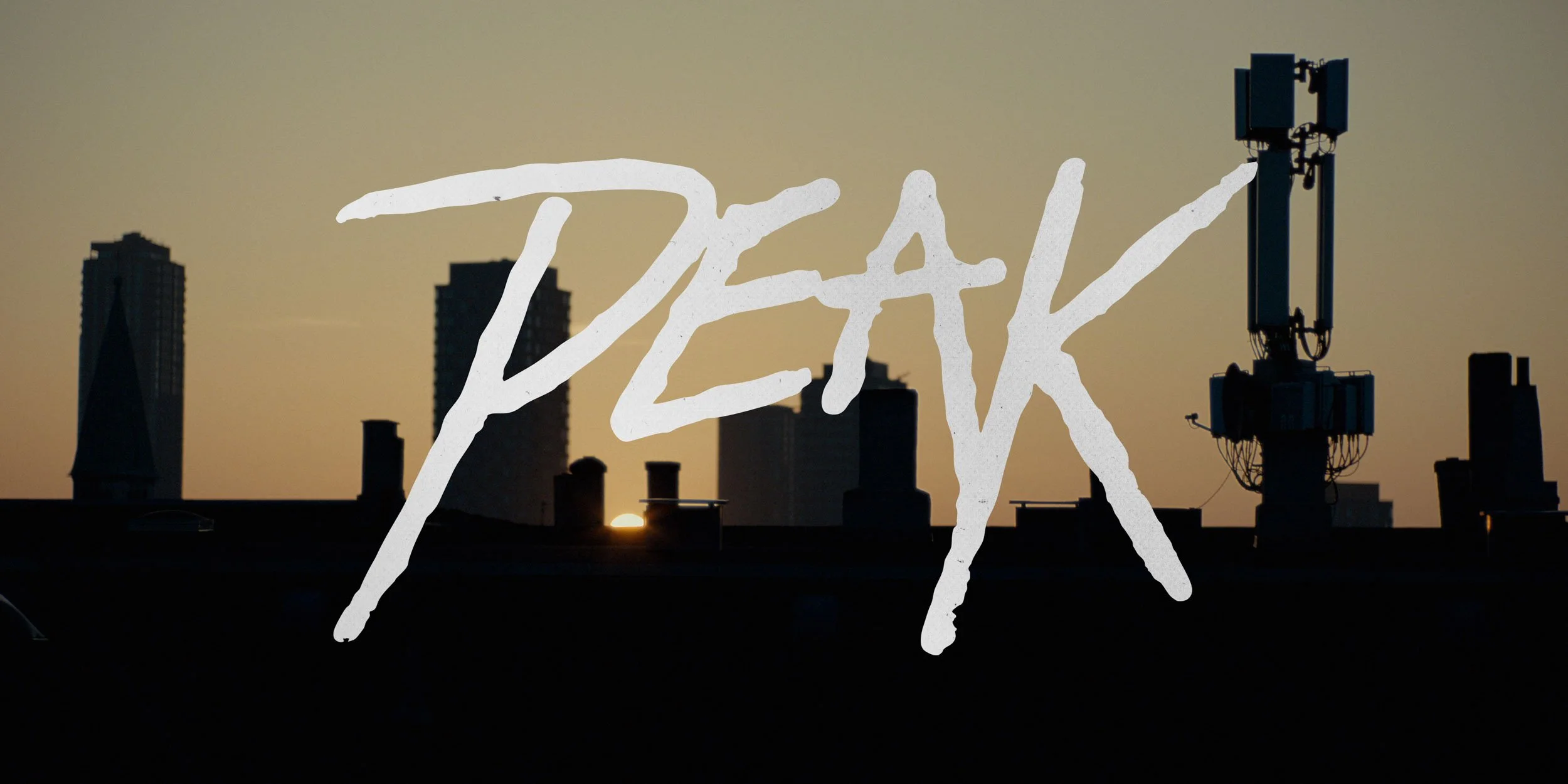 City skyline silhouette during sunset with the word 'PEAK' written across the image.