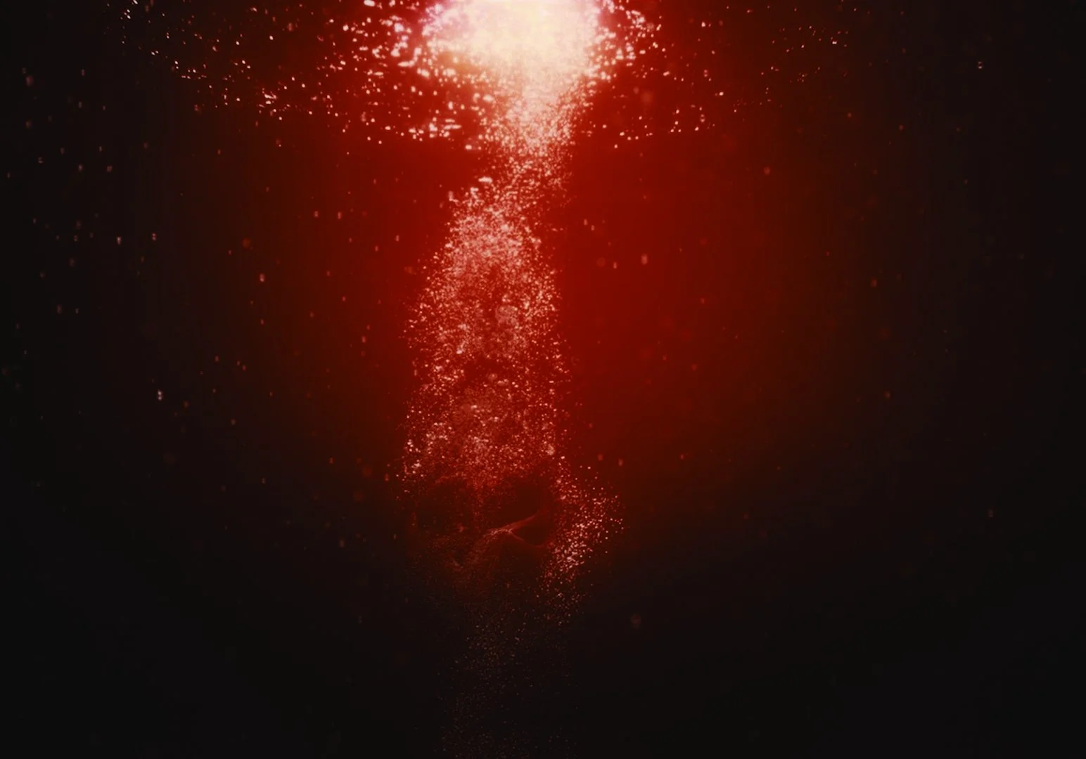 Red glowing spark particles forming a vertical column in dark background.