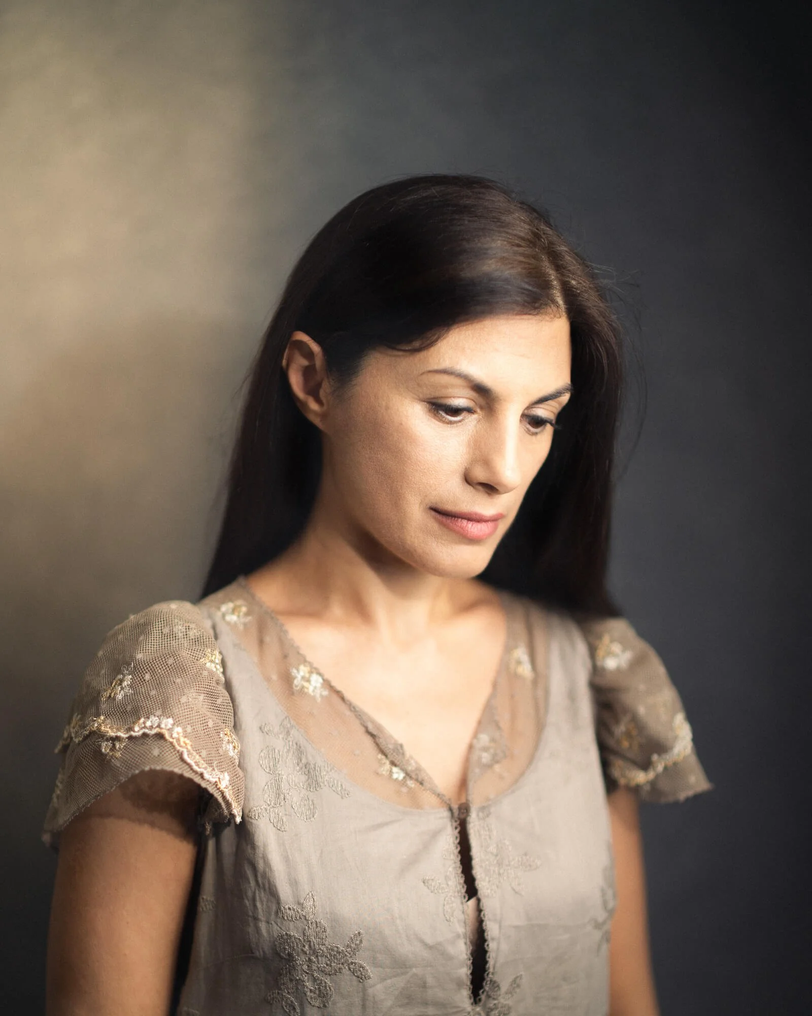 Headshot of woman looking down, starting a photography business