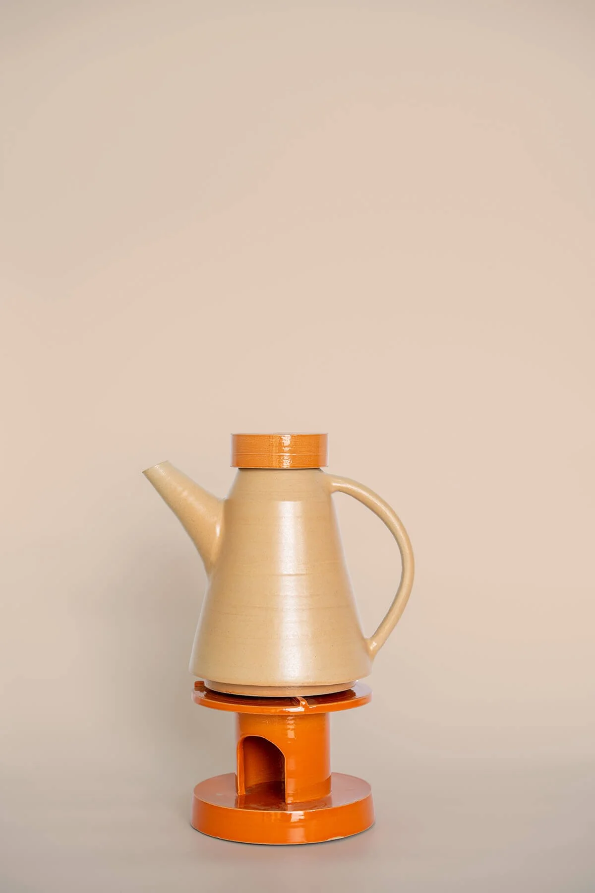 Handgemaakte steengoed theepot met bijpassend rechaud in zacht oranje en glanzend diep oranje, ontworpen in het keramiekatelier LAB L.L. in Vlaardingen.