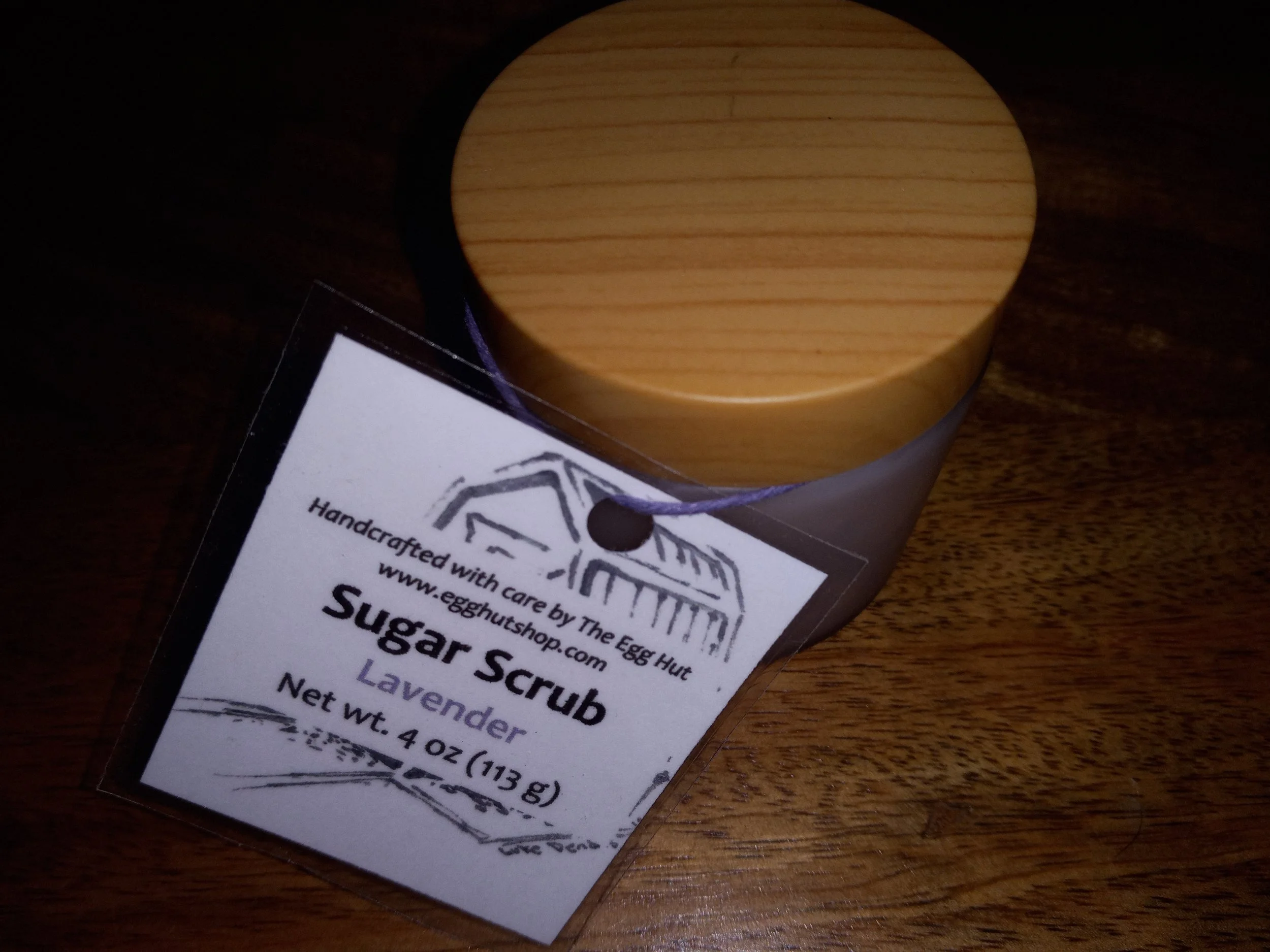 frosted jar with wooden lid and sugar scrub label.
