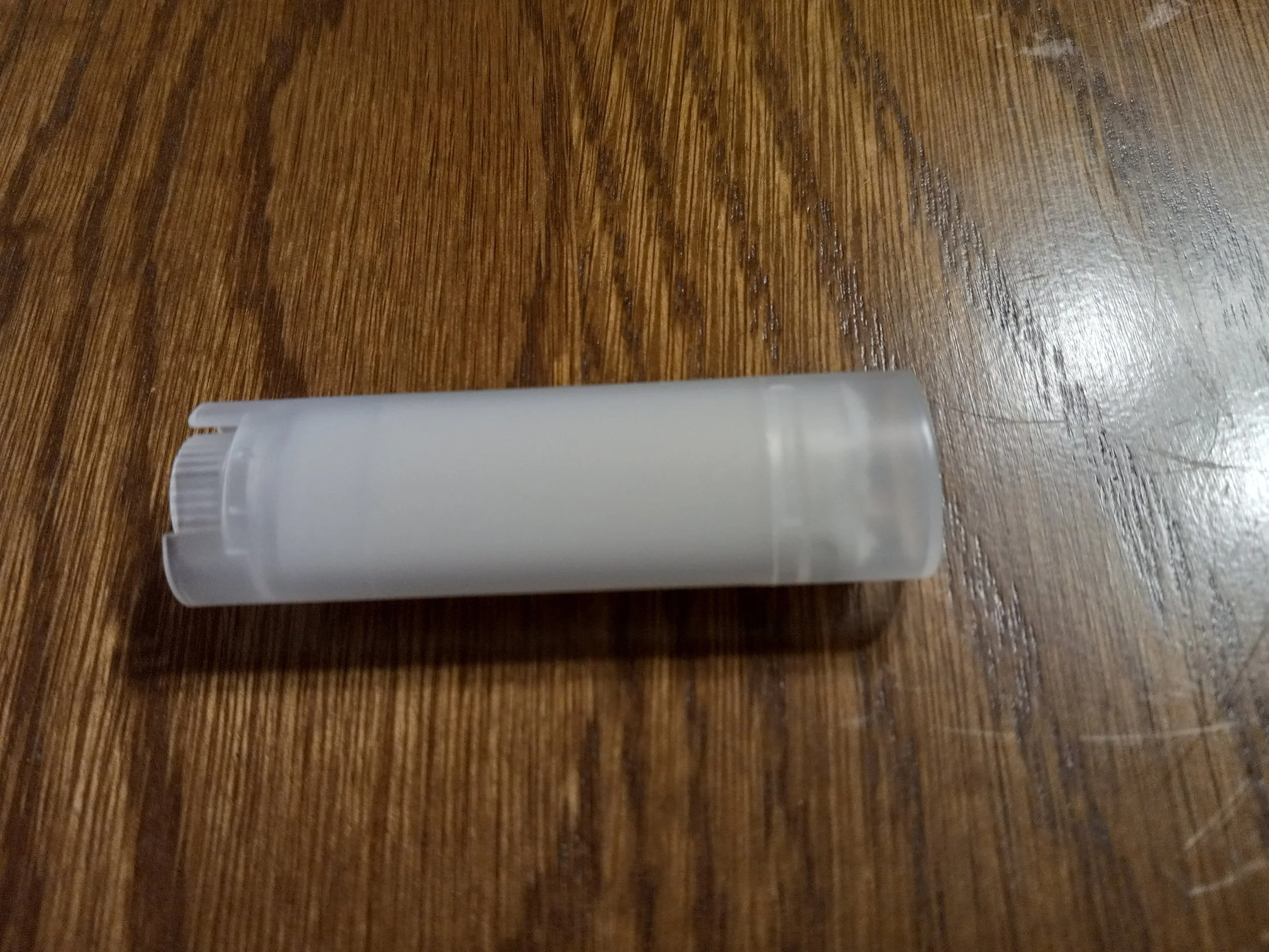 clear oval tube of white lip balm.