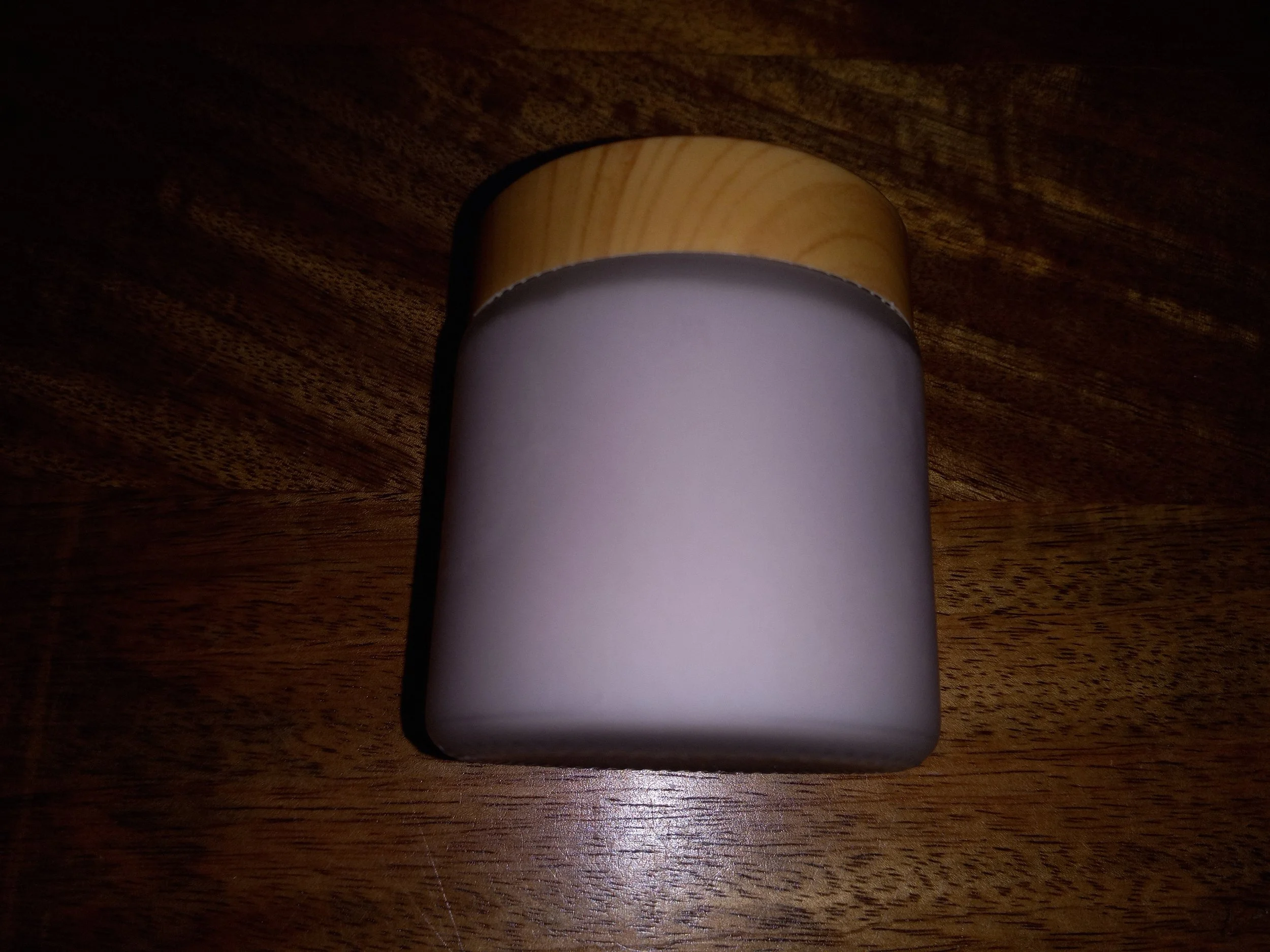 frosted jar filled with lavender scrub and covered with wood lid.