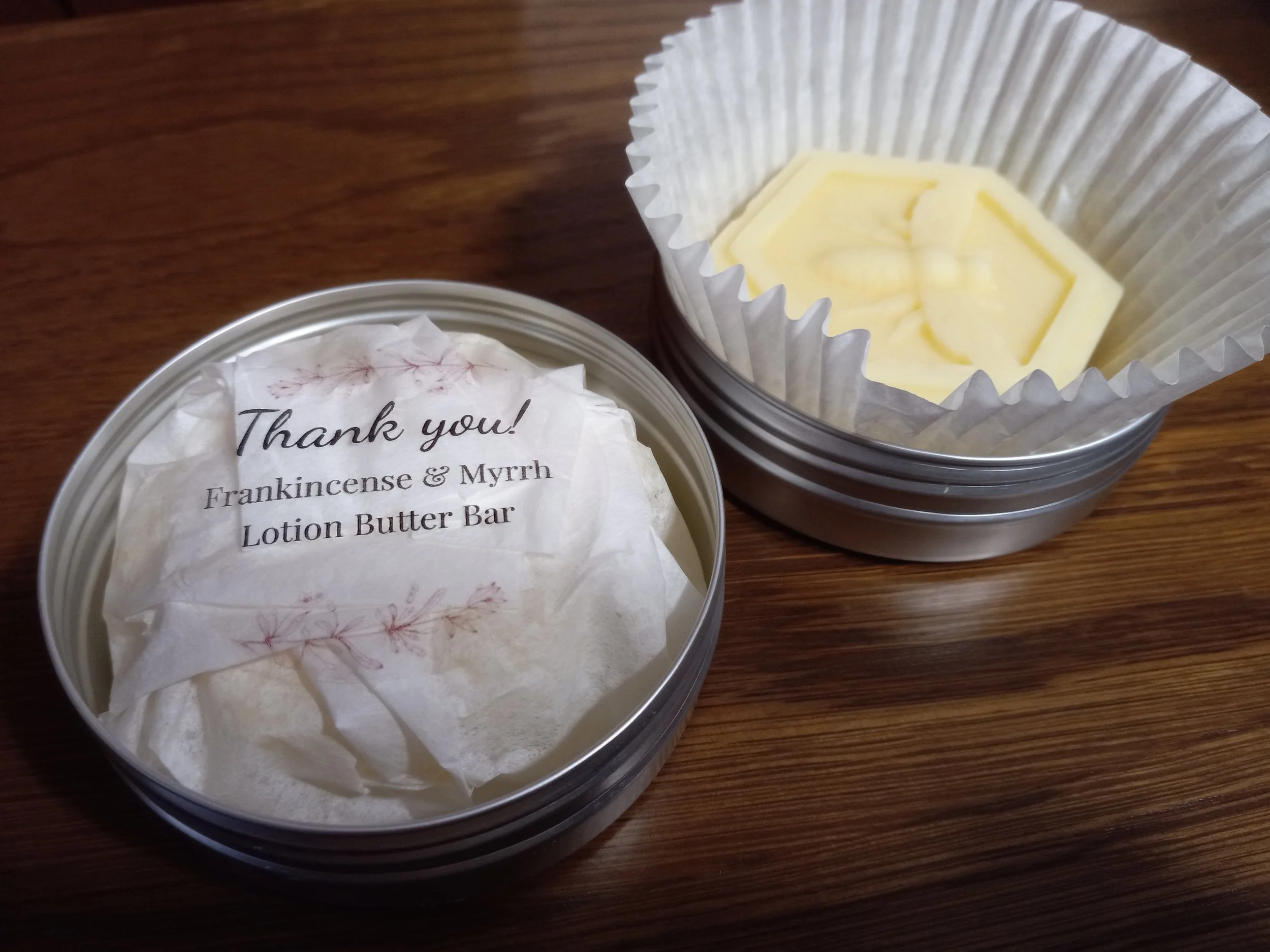 2 tins one is wrapped and the other has a bar displayed.