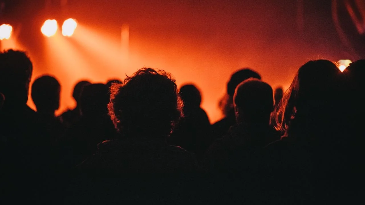 Audience watching a concert with orange stage lighting