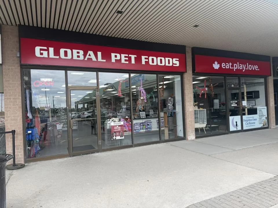 Storefront with a red sign reading 'GLOBAL PET FOODS' and a slogan 'eat.play.love.'"