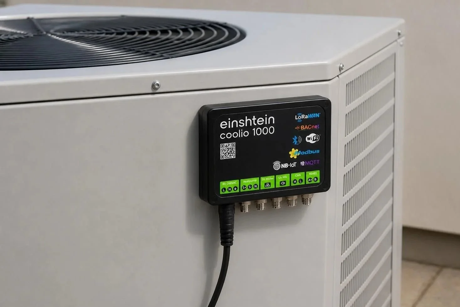 Close-up of a white air conditioning or refrigeration unit with a black einshtein Coolio 1000 control module attached to its side, showing various technical icons and labels.
