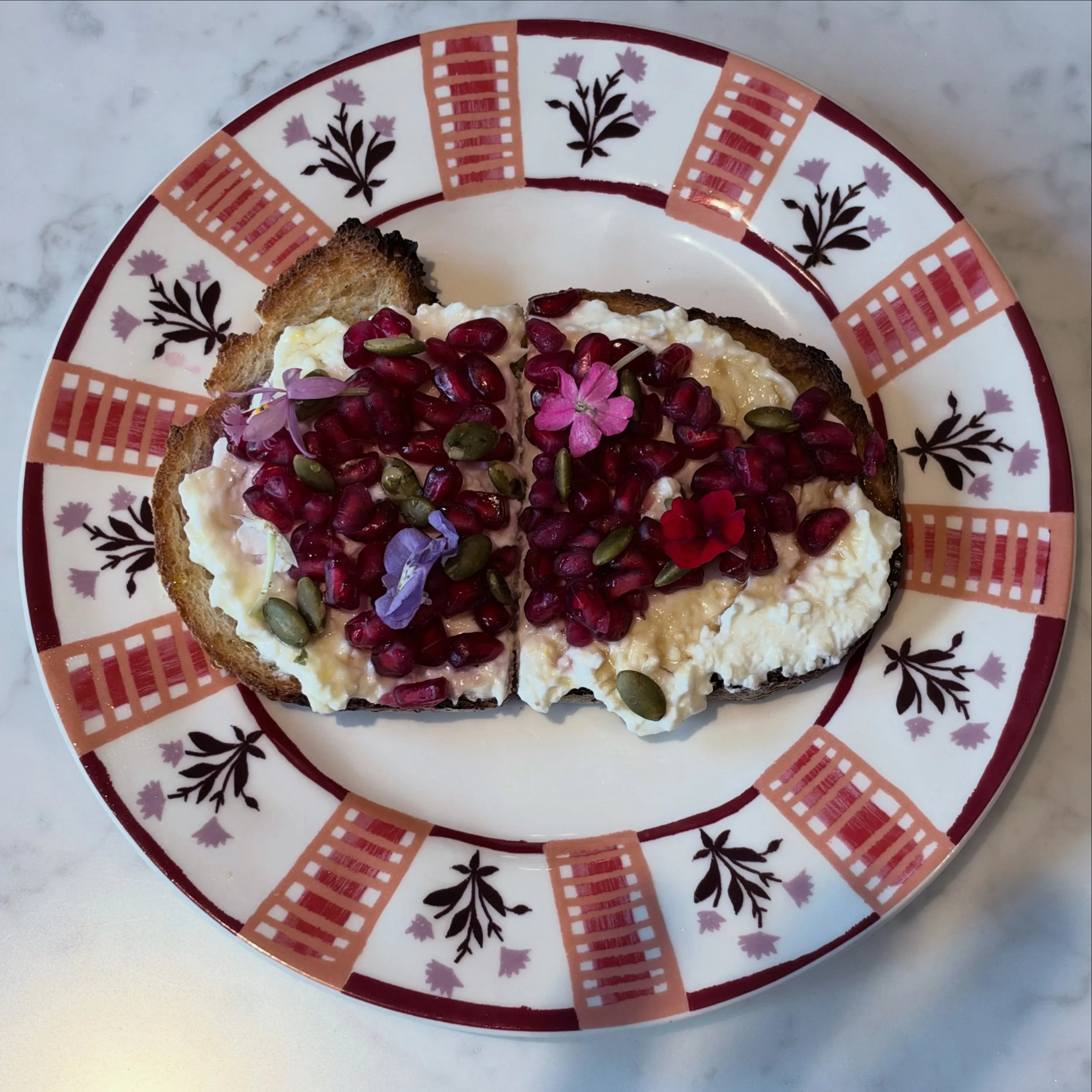 Our seasonal toast is a whipped feta with pomegranate seeds, toasted pepitas and a honey balsamic drizzle on your choice of bread
