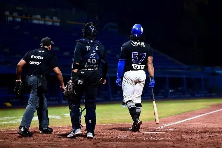 Caleb Marquez, MFIG owner and coach, wearing #57 and walking back from the plate during a professional game.