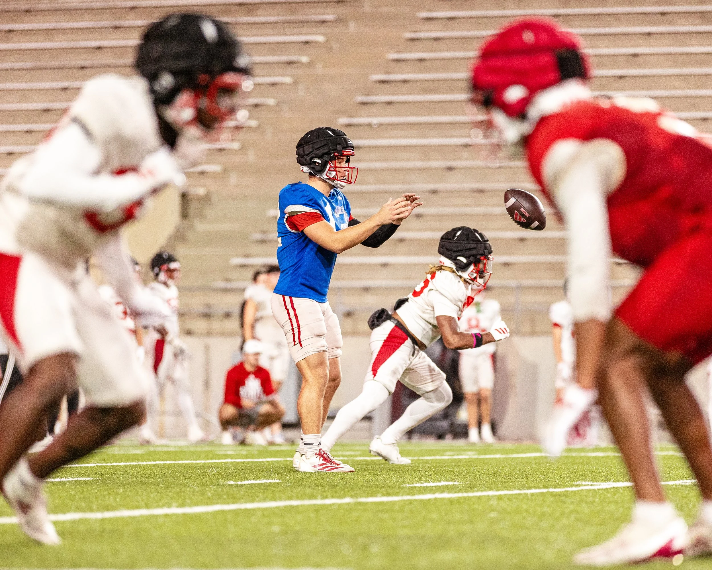  I think this photo is one of my best because you have the QB catching the ball while he is framed in between the defender and the offender.