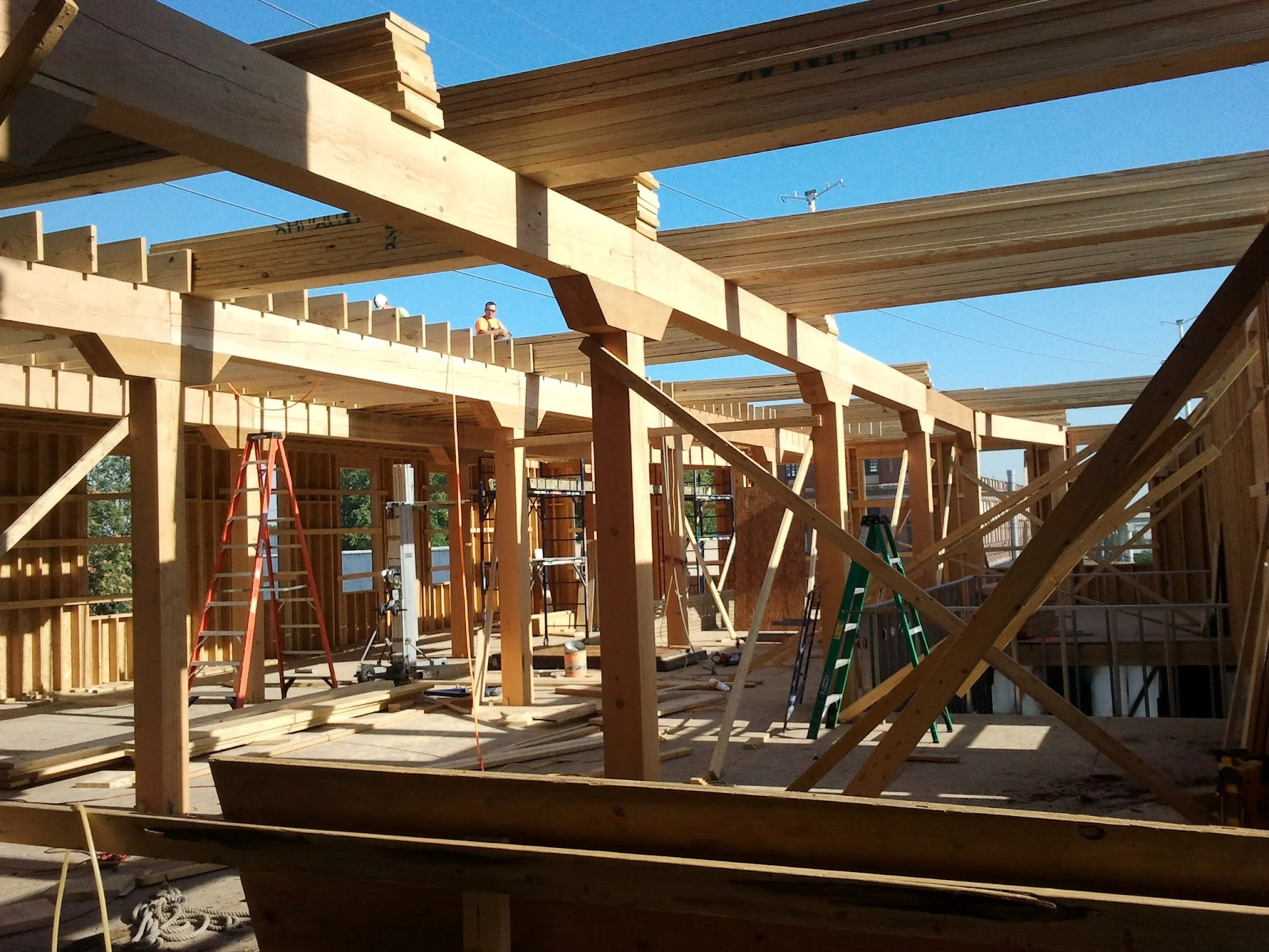 Construction site with wooden framework, ladders, and scaffolding in progress.