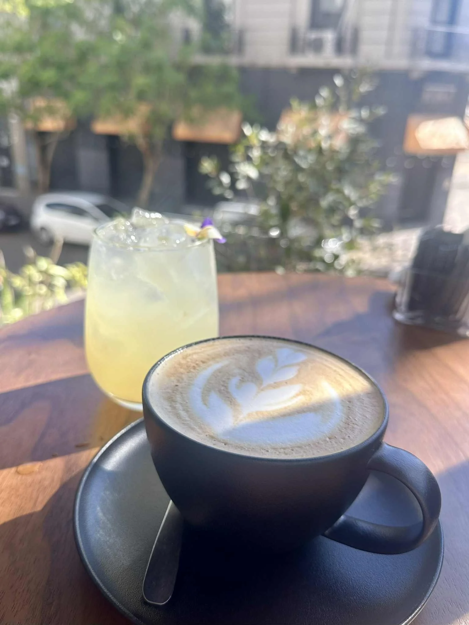 Highlighted by a ray of sun are a lemonade, and a vanilla late, on an outdoor terrace cafe in Argentina
