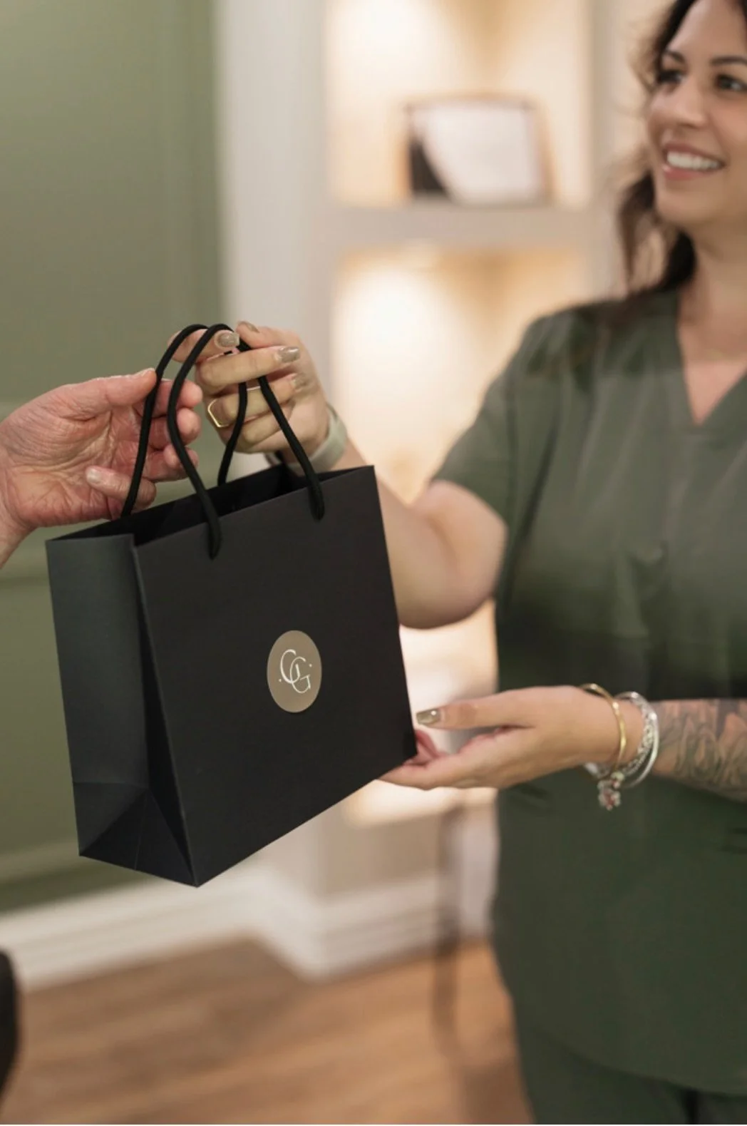 Lady in green scrubs handing over bag