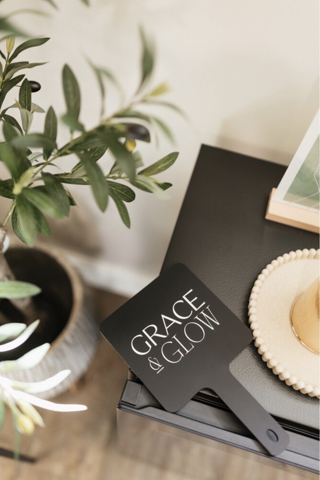 Grace and glow mirror on fridge with olive tree in background with candle