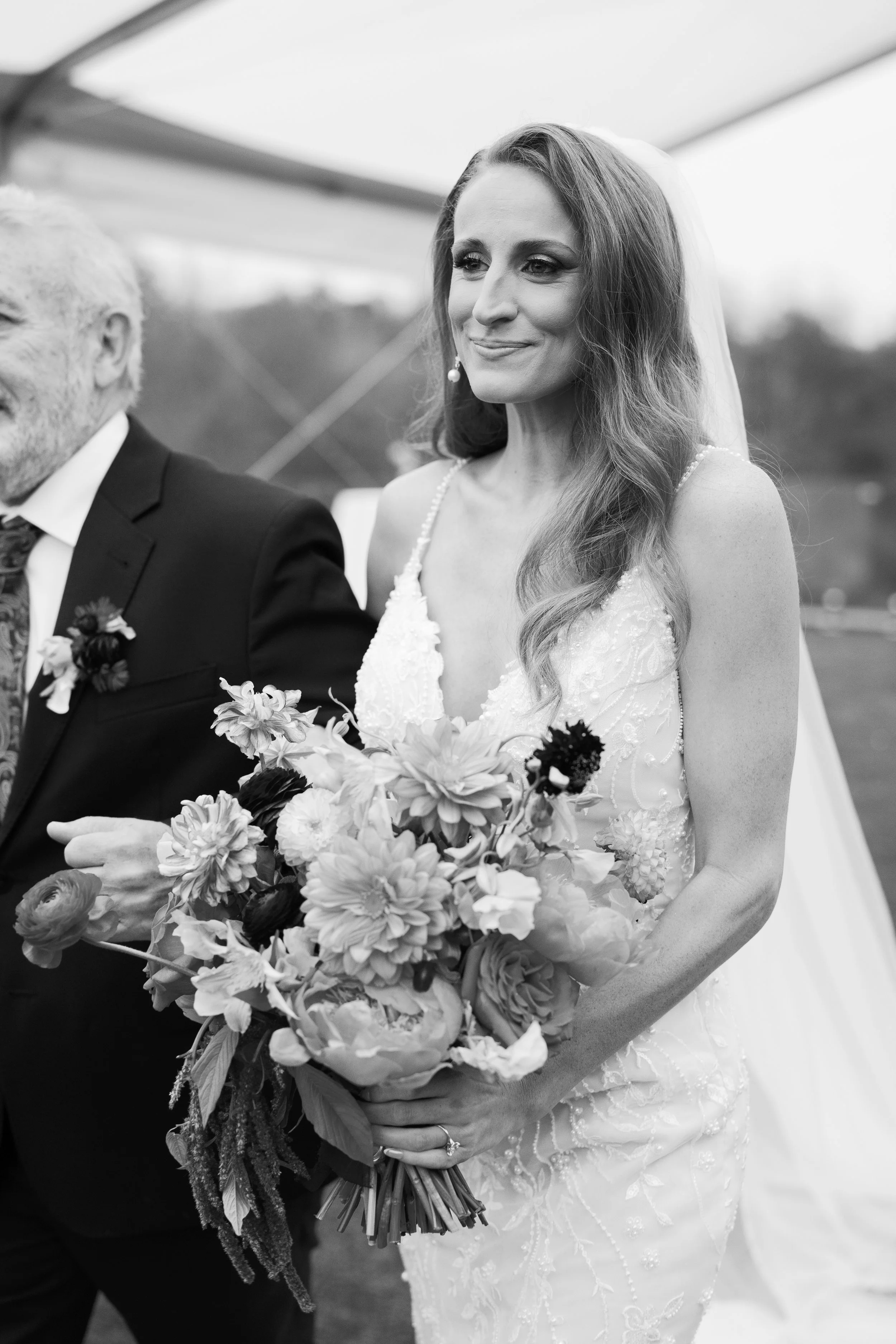 Bride smiling while being walked down the aisle holding bouquet, West Tennessee wedding photographer