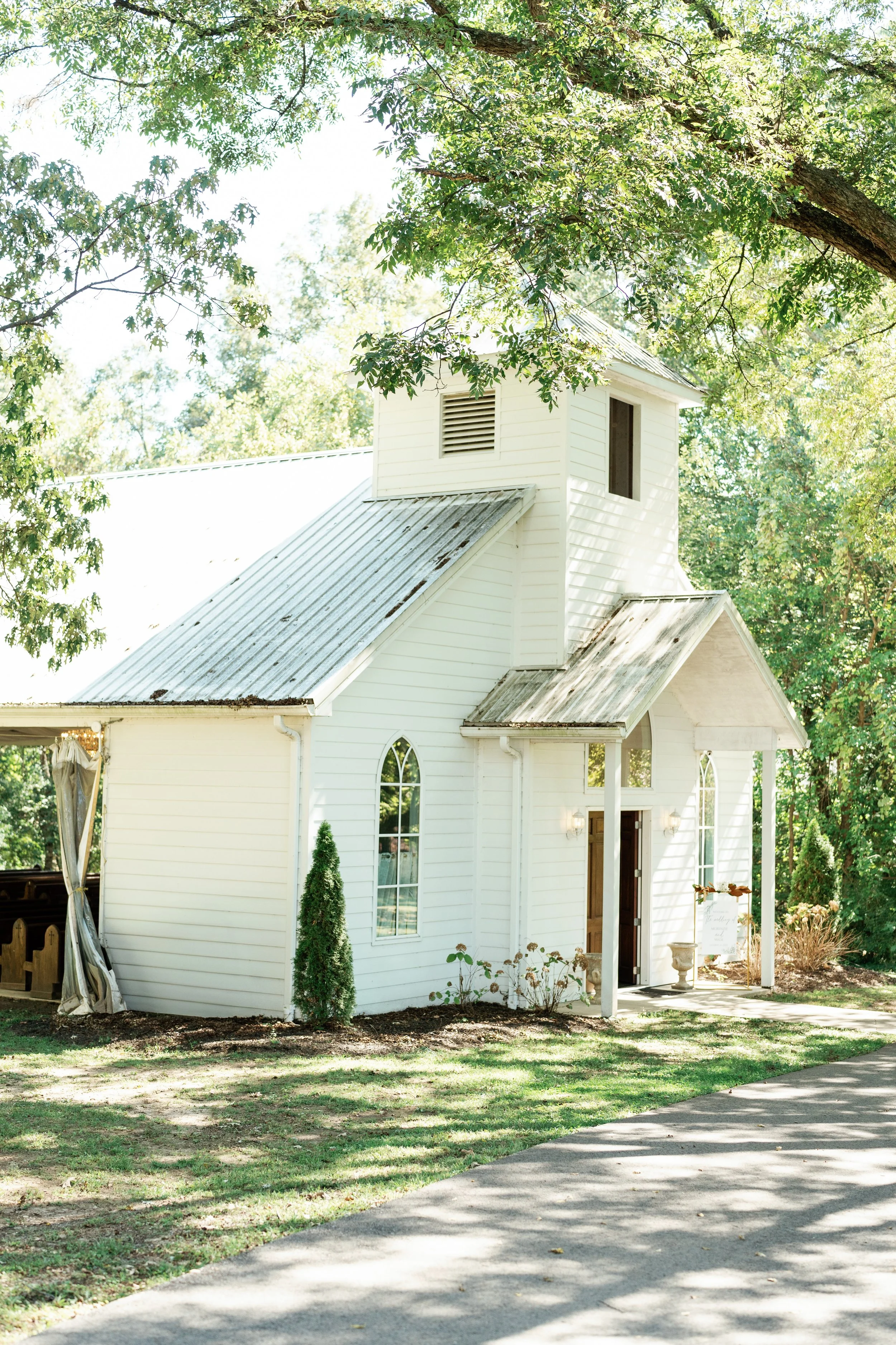 White outdoor wedding chapel surrounded by mature oak trees at The Venue at Twin Oaks in Humboldt Tennessee