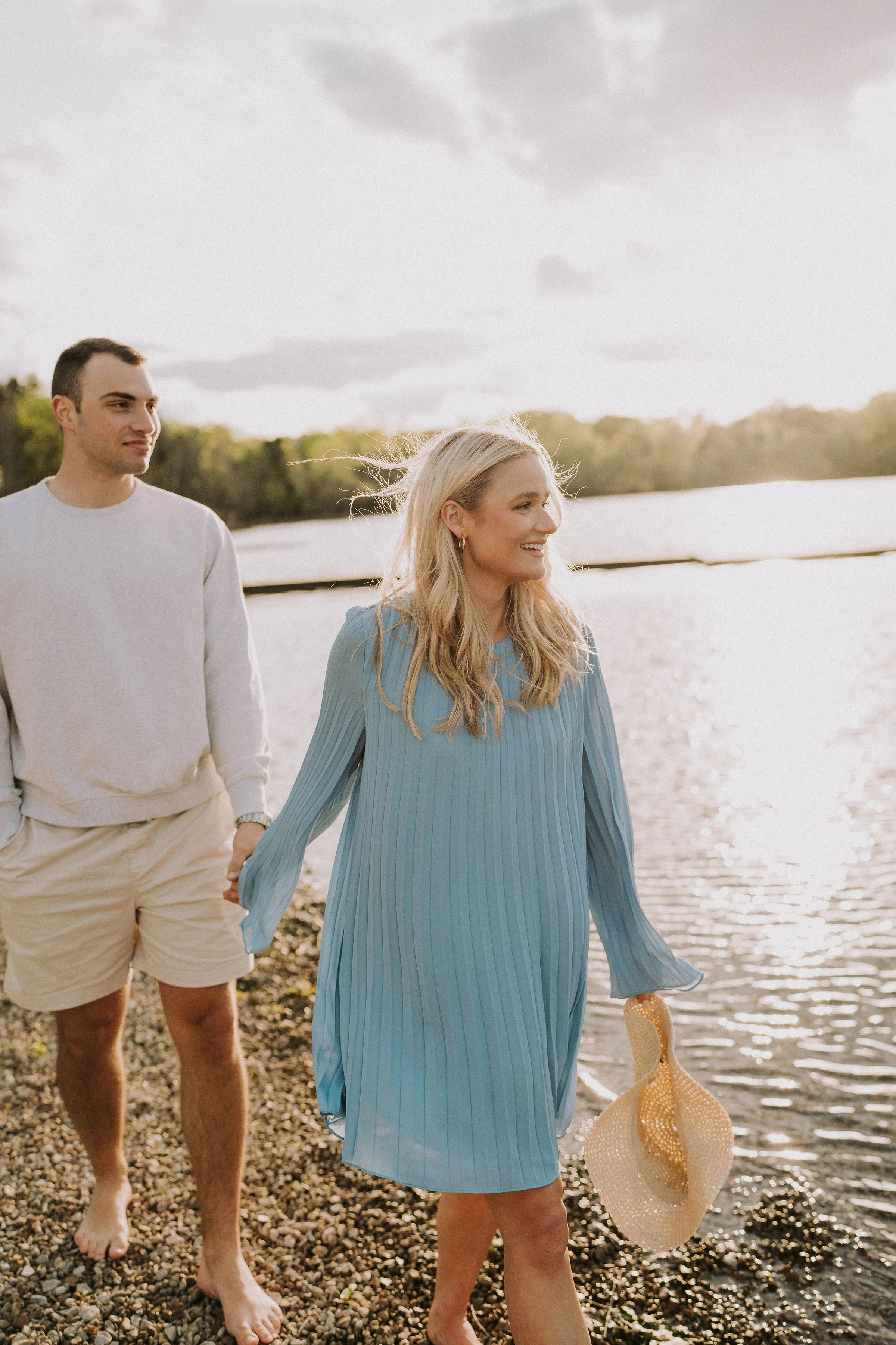 couple walking lakeside in blue dress — natural engagement session West Tennessee photographer