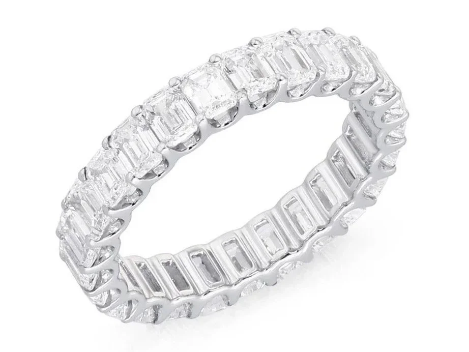 Diamond eternity band ring with alternating square and rectangular cut diamonds.