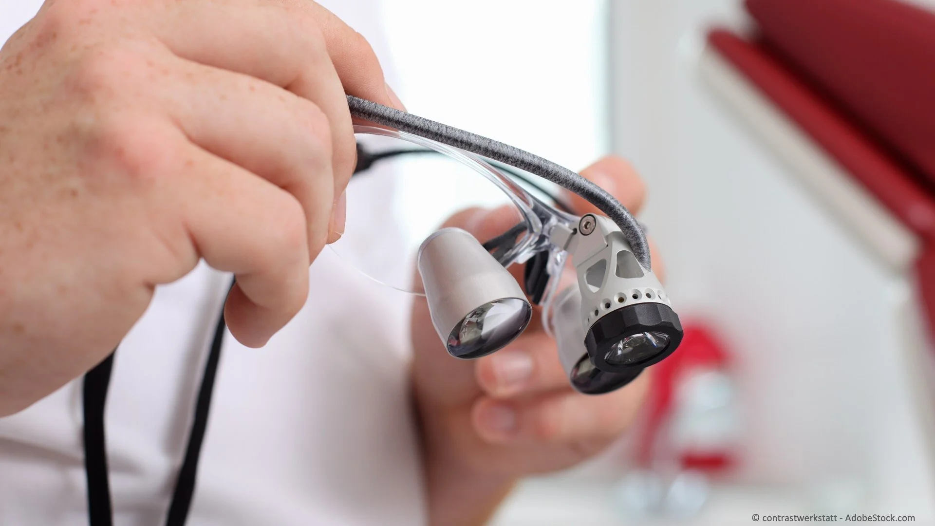 Nahaufnahme einer Hand, die eine gebrauchte chirurgische Stirnlampe hält.