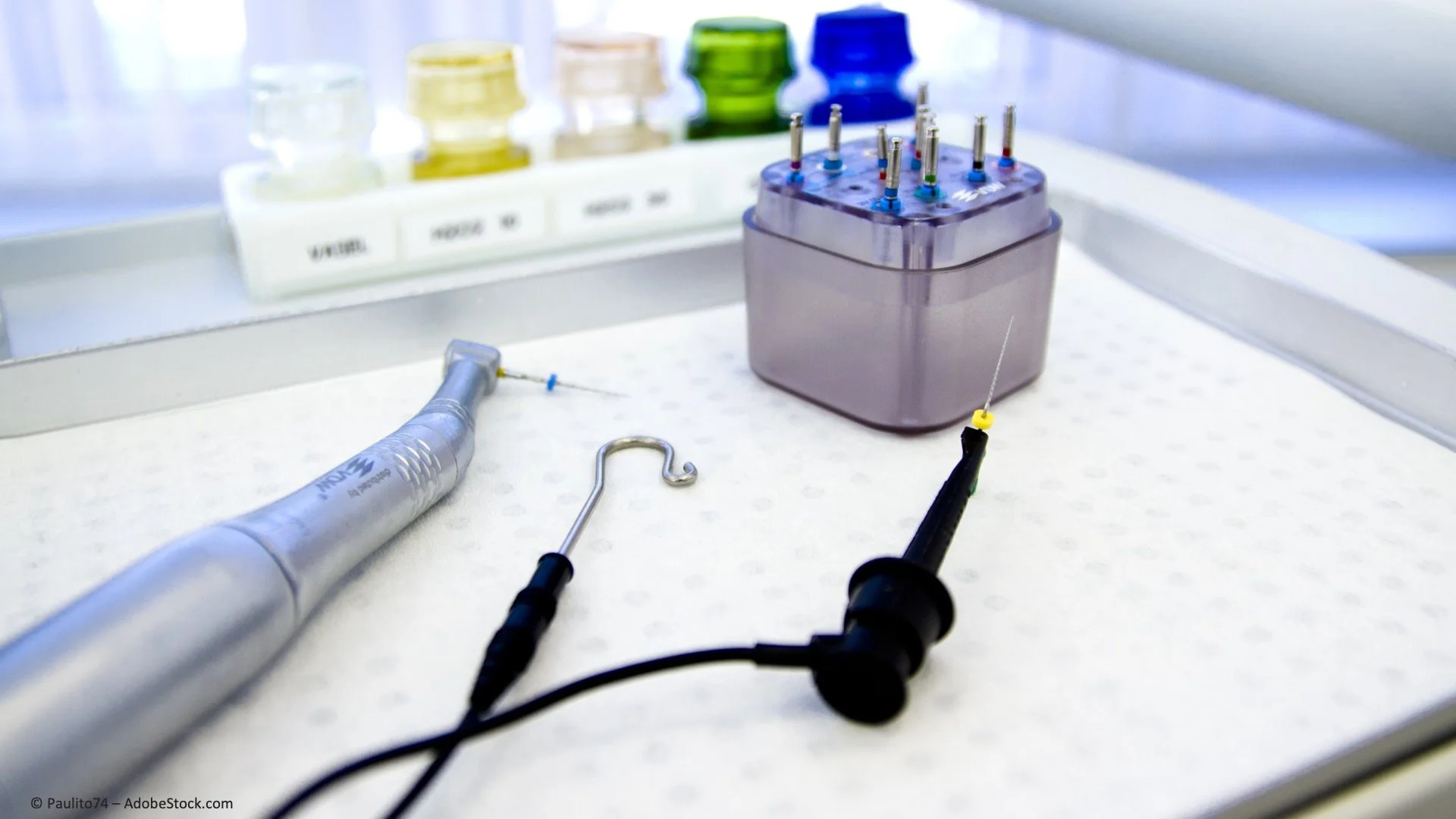 Laborgeräte und -instrumente, darunter eine zahnärztliche Sonde, ein Ansteckstück, ein Inspektionskabel, eine Box mit verschiedenen kleinen Instrumenten, auf einem weißen Tisch