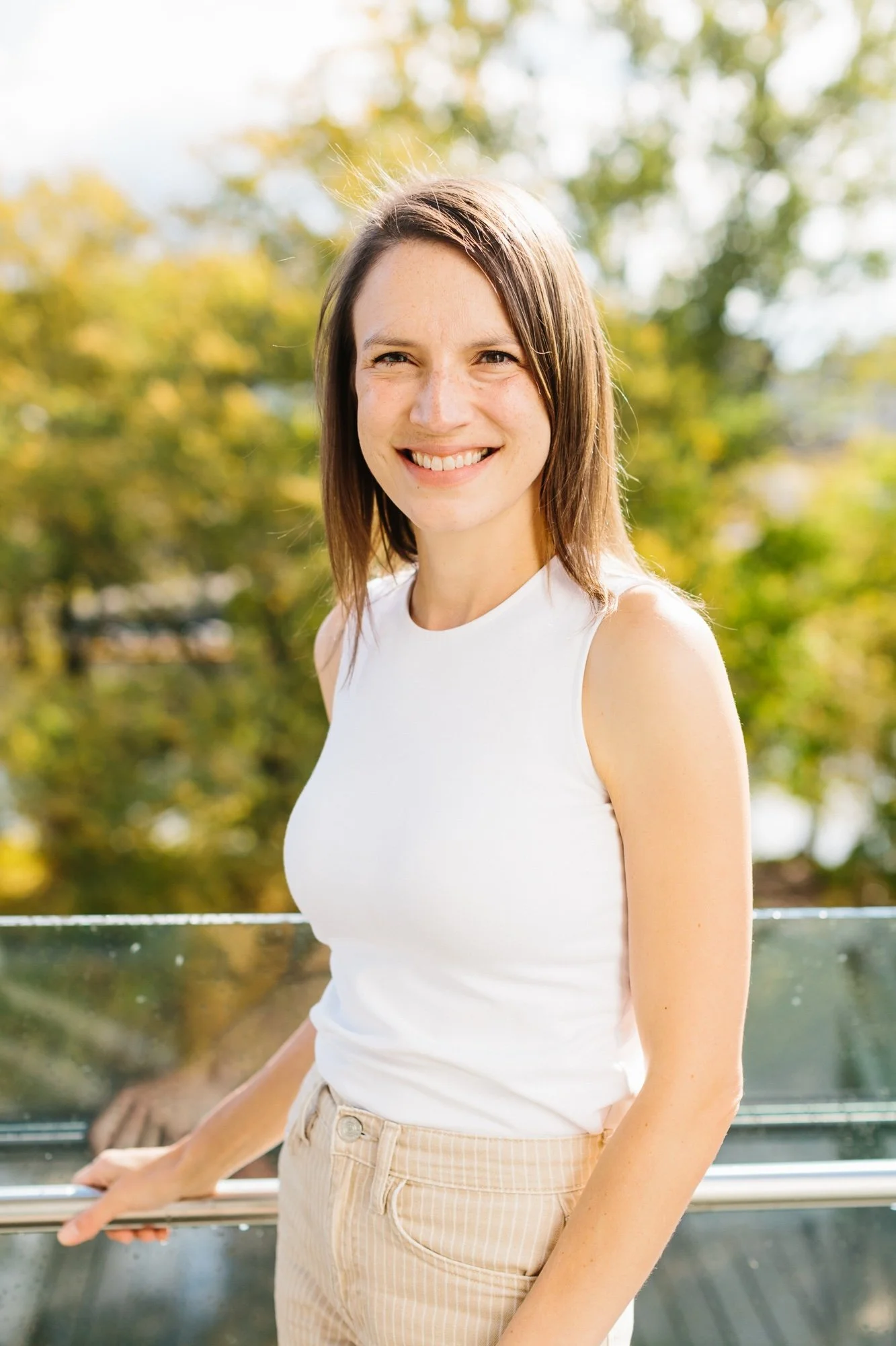 Abby Priebe career coach smiling on patio. Career coach for millennials and Gen Z in Grand Rapids Michigan.