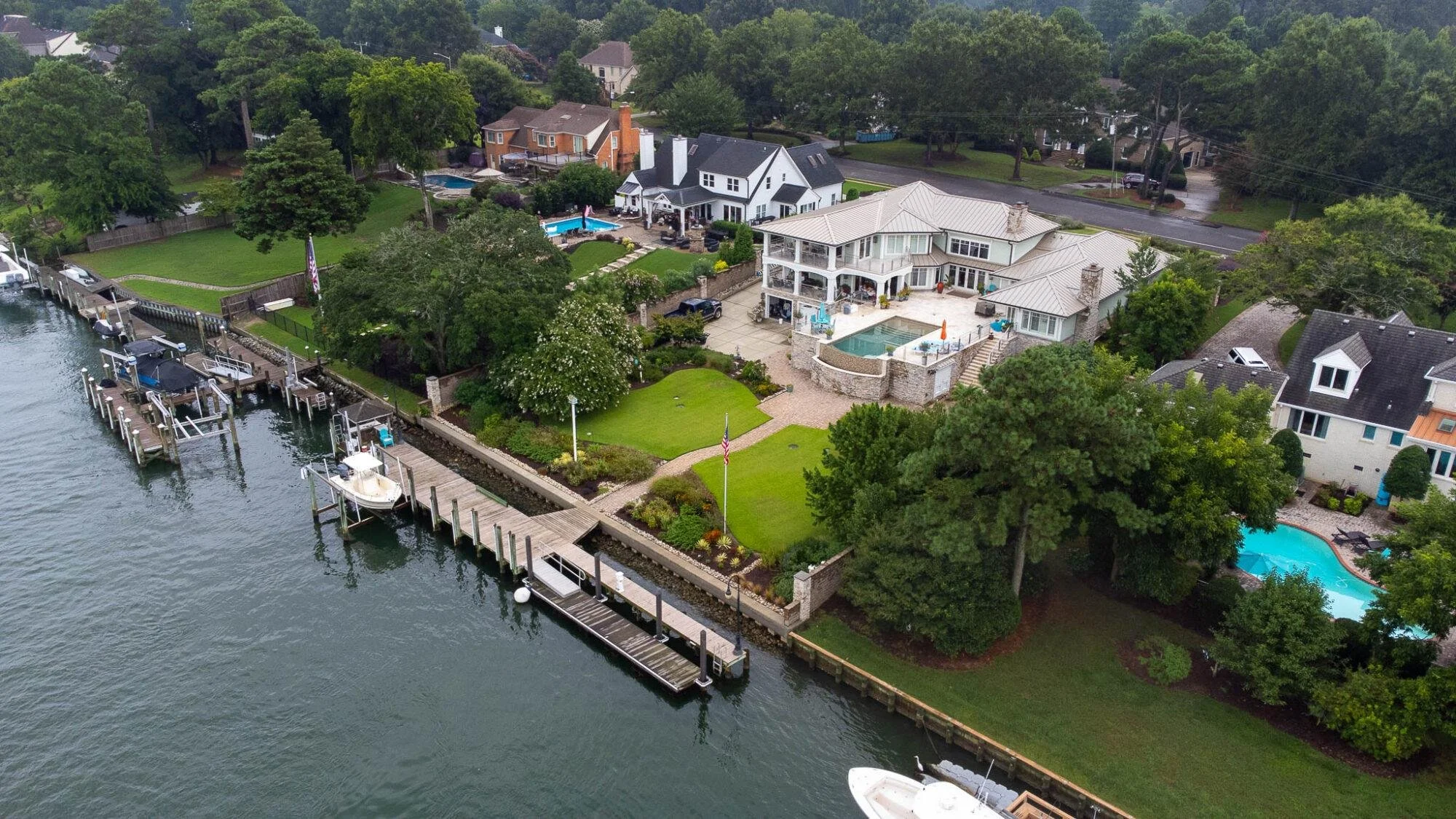 Aerial view of waterfront homes with backyard pools and docks in Little Neck, Virginia Beach