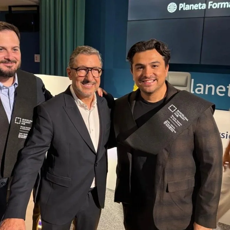 Tres hombres en atuendos formales en un evento, uno con barba, otro con gafas y cabello rubio, y el tercero con cabello oscuro. Detrás hay un cartel que dice "Planeta Forma".