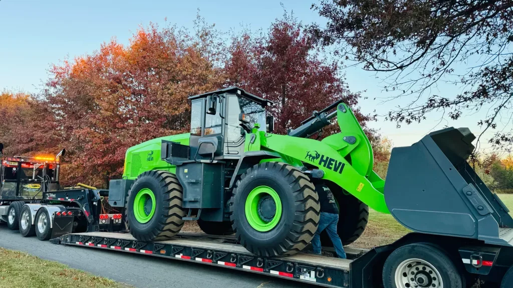 The H65L wheel loader on a flatbed trailer getting ready to leave.