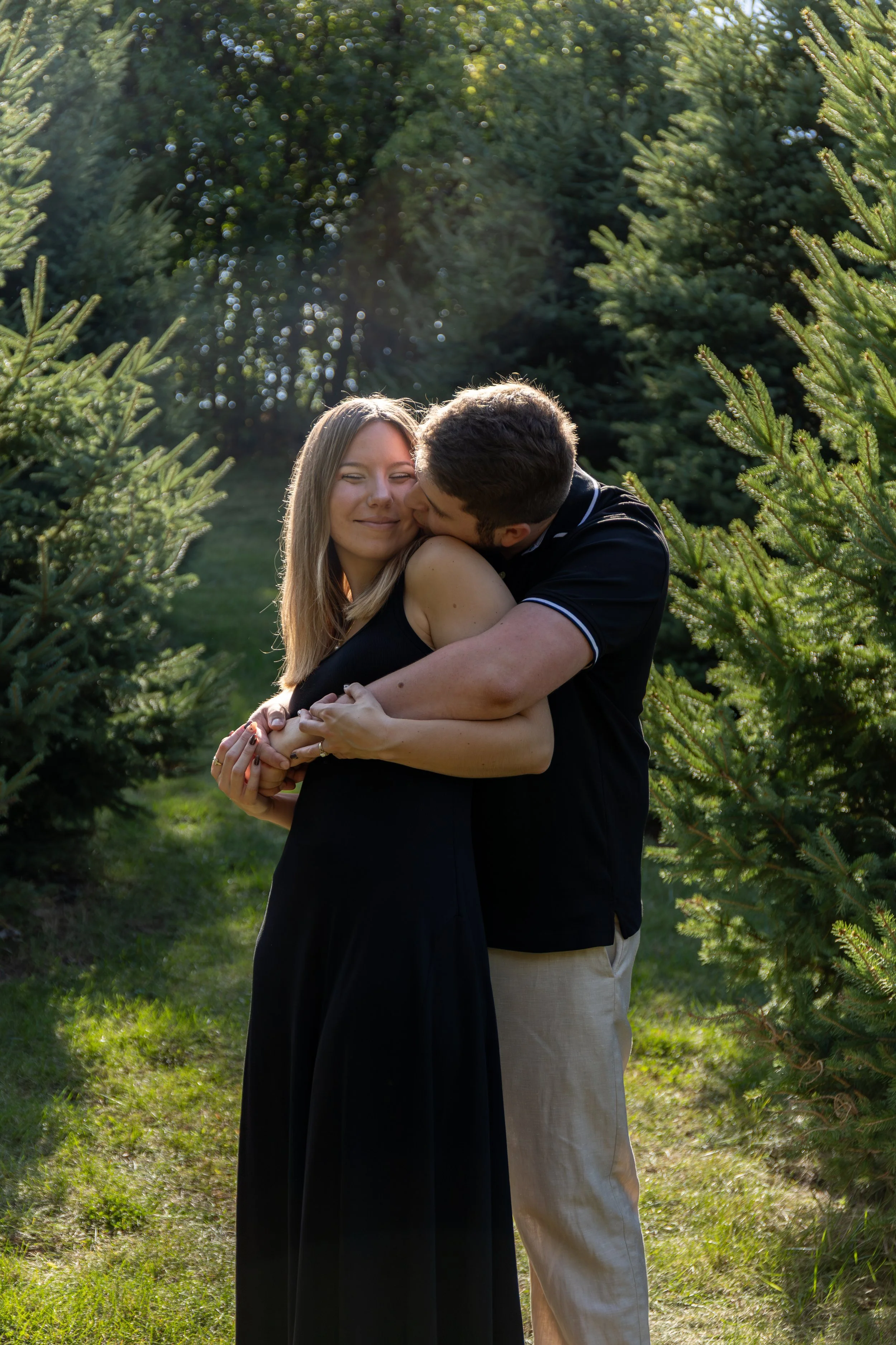 young couple in love among green pine trees in Wisconsin
