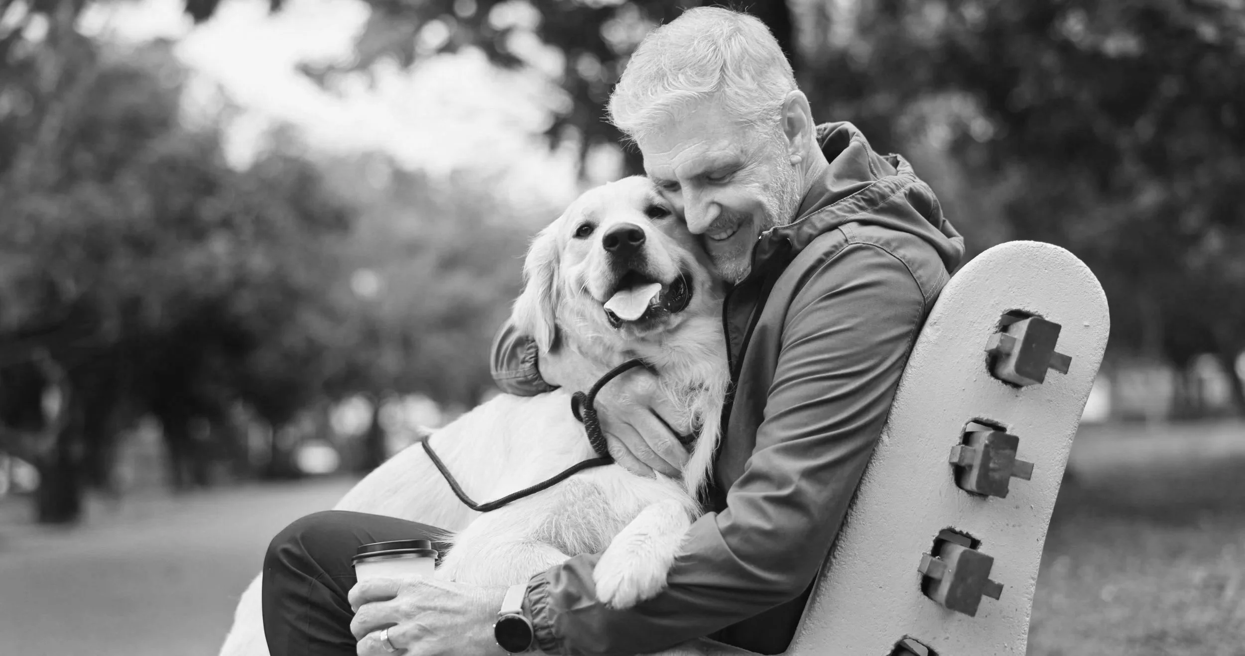 Smiling middle aged man hugging his dog